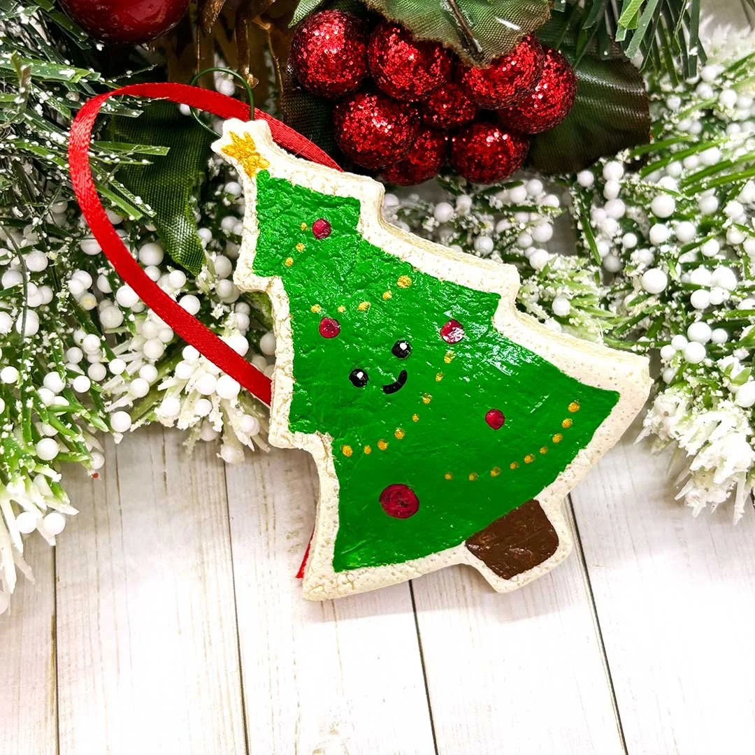 Smiling Christmas tree cookie ornament.