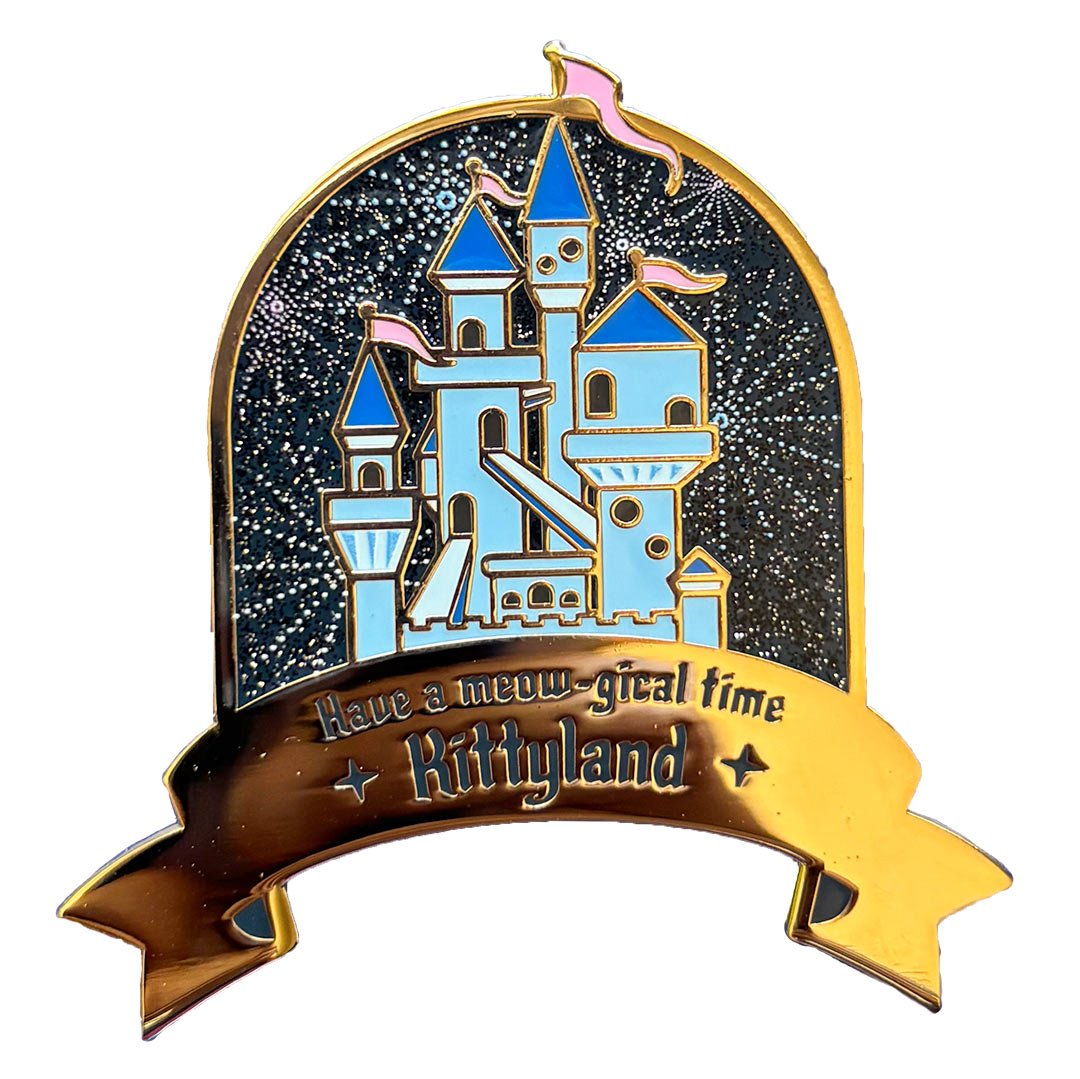 Enamel pin of a blue fairy tale castle with fireworks and a banner on the bottom that says 'Have a meowgical time at Kittyland'.