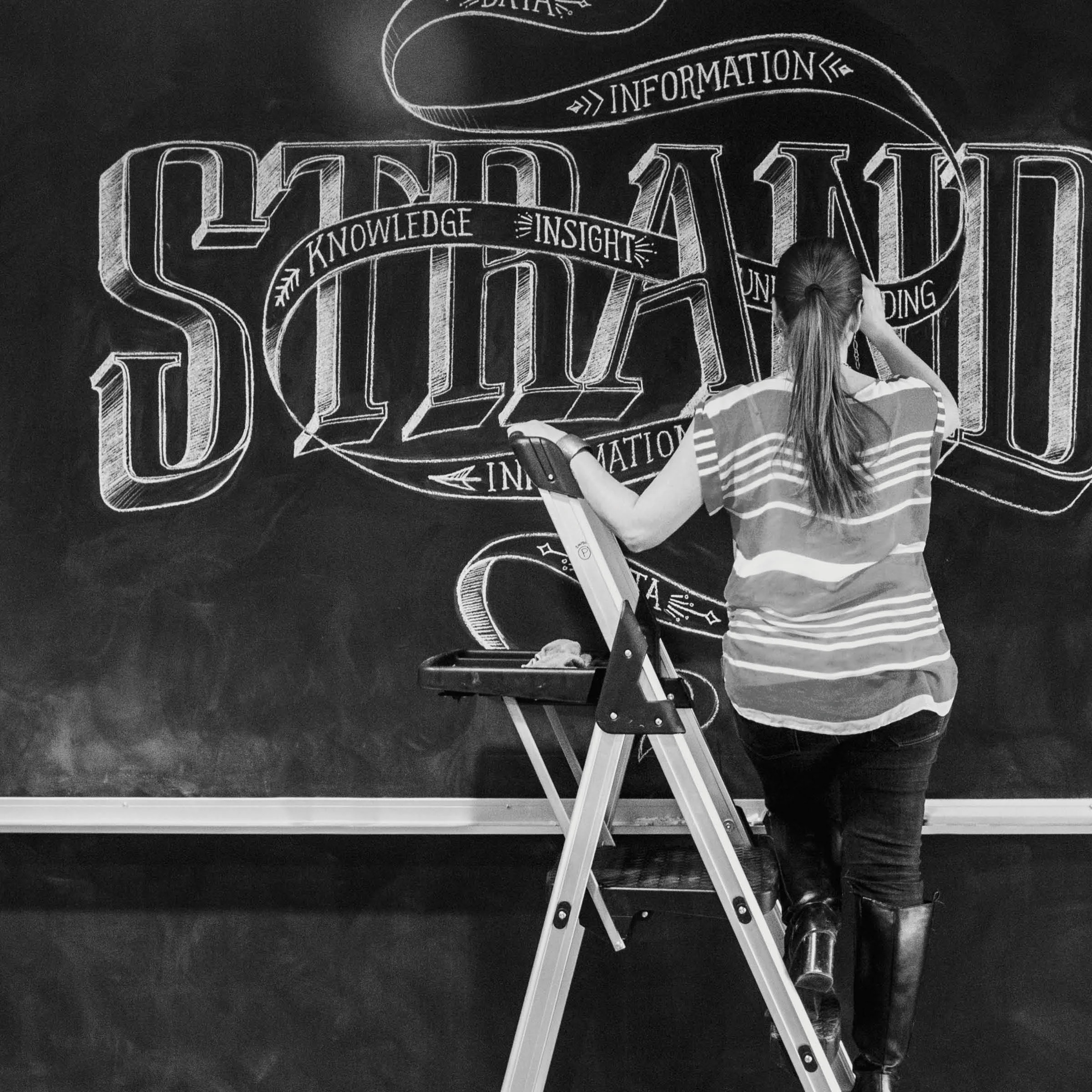 Chalk Mural Installation at GTB We worked on-site to create a 50-foot chalk wall installation in the lobby of Detroit-based GTB (Global Team Blue). The mural contained three typography-based compositions inspired by content that they provided.
