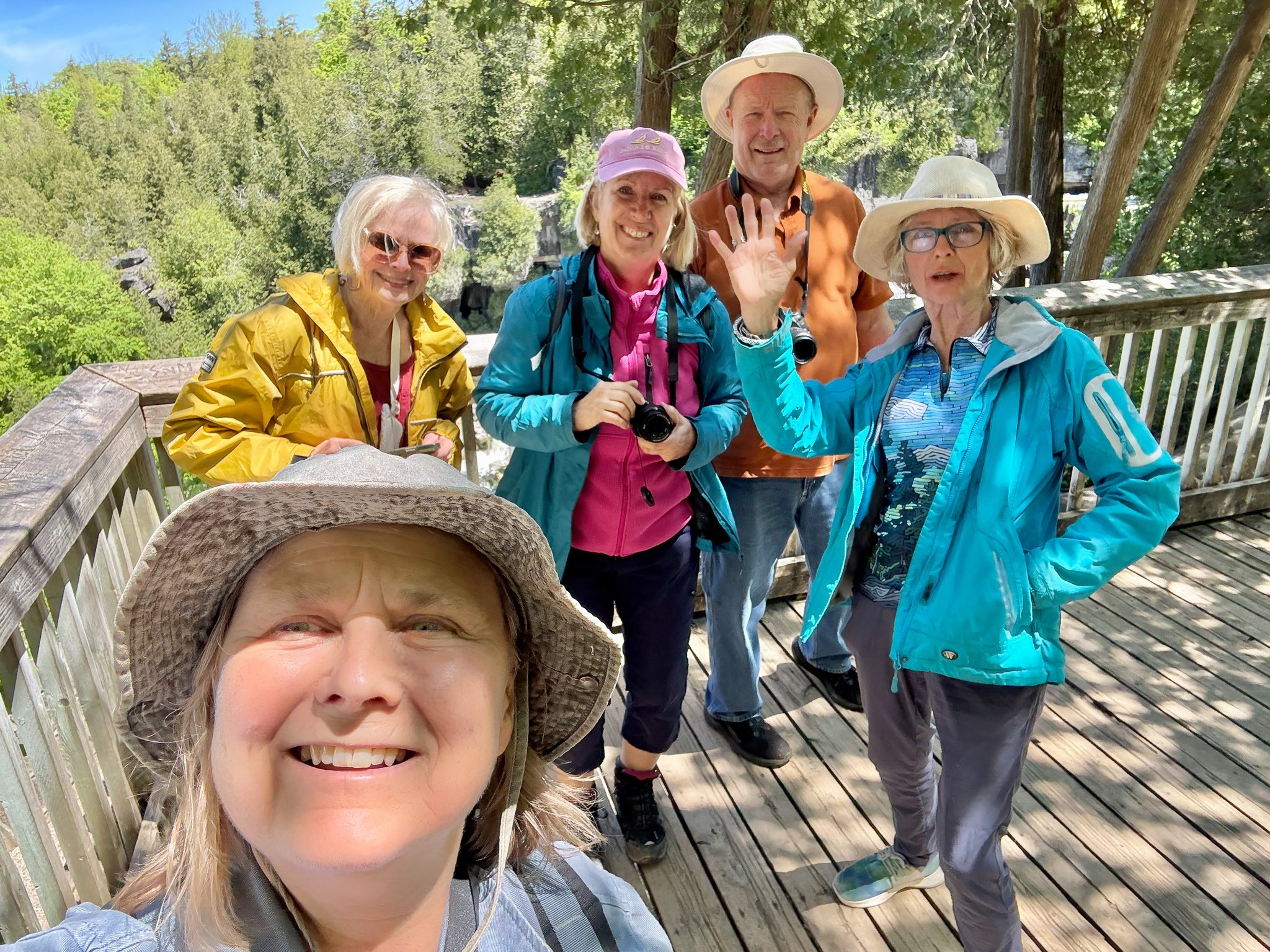 Image shows the five artists who make up the Bruce Trail Inspired III collective. It is a candid selfie with Anne More, Cathy Lorraway, Rob Peachey, and Victoria Pearce smiling at the camera as Janet Jardine takes this selfie of them all.