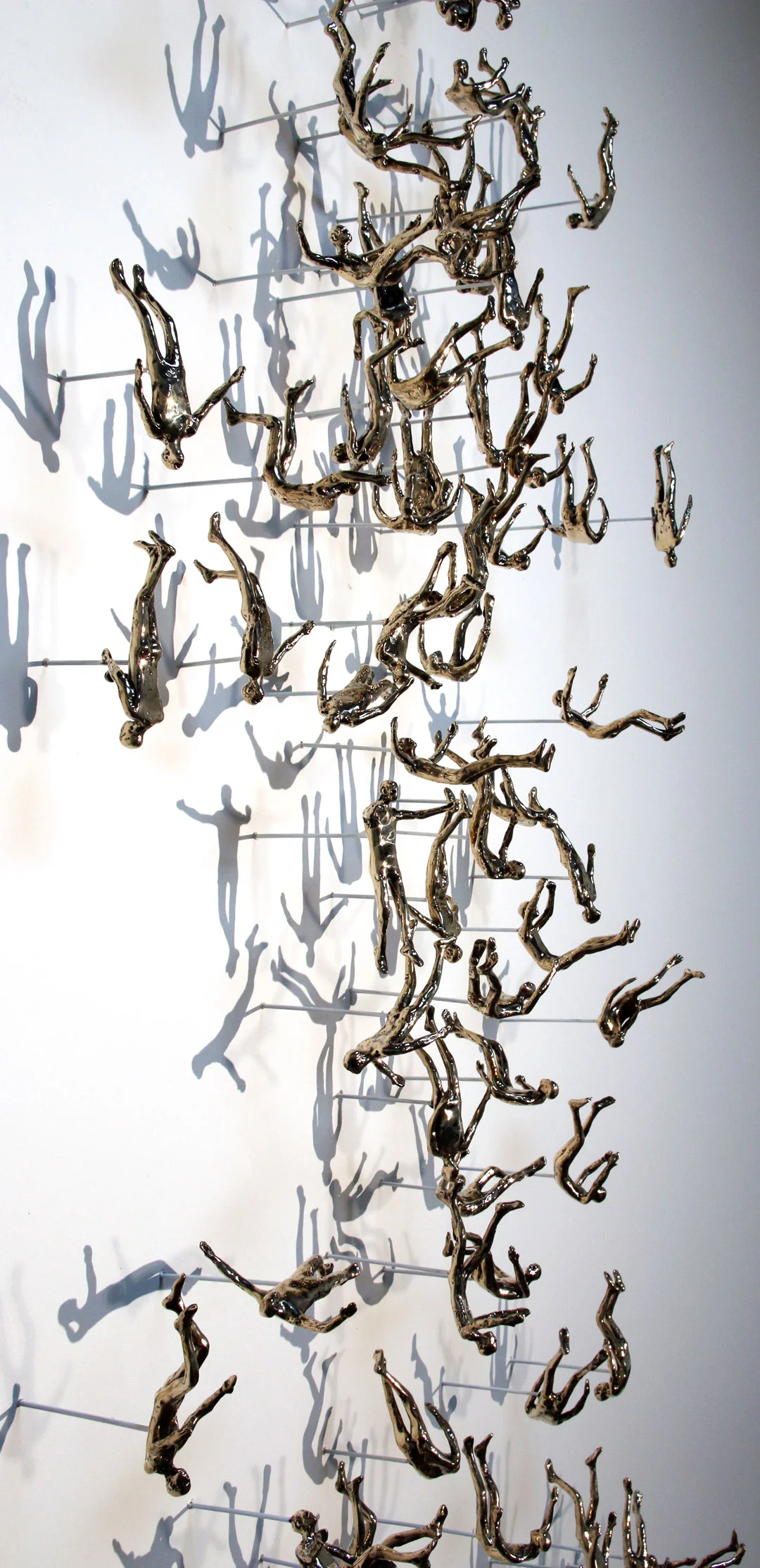 "Falling Man #2", 2015, polished bronze, 96 figs, wall mounted, unique, each fig. approx 5" H