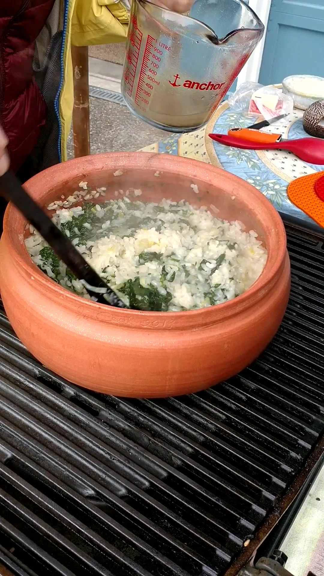 Making spinach risotto in a dutch oven on a propane grill.