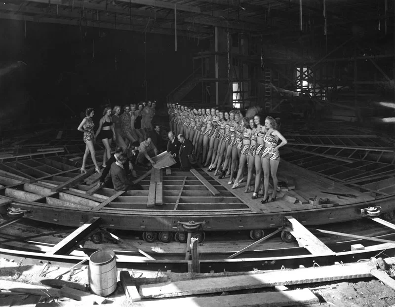 Earl Carroll with some of his aides and chorus girls examining construction of the moving stage. Photo via Los Angeles Public Library (1938).