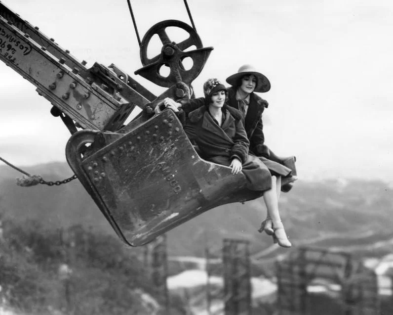 Publicity photo of women in a steam shovel above Hollywoodland. Photo via Los Angeles Public Library (1924)