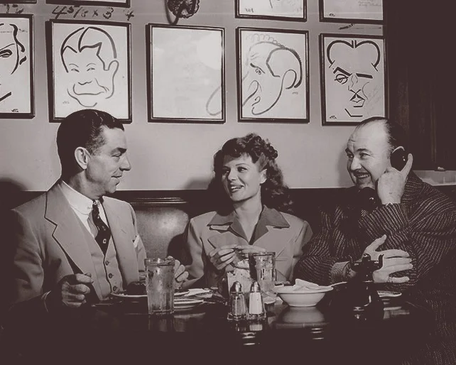 Robert Cobb, Rita Hayworth, and Paul Whitman at the Hollywood Brown Derby (1949). Photo via The Hollywood Reporter.