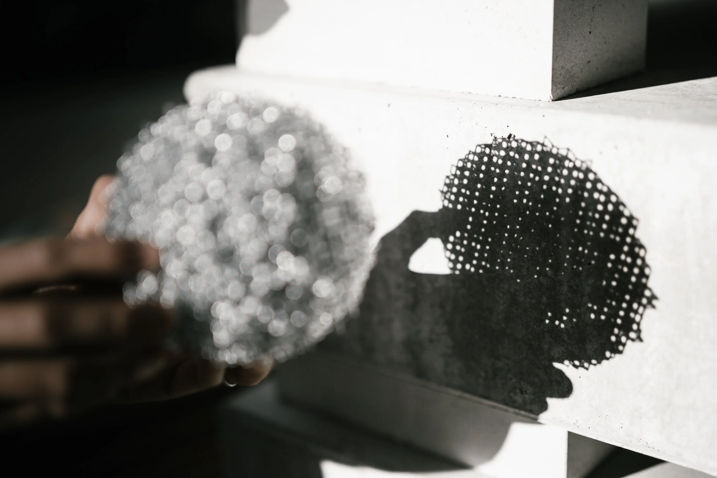shadow cast of a 3d printed icosahedron sphere on a concrete slab