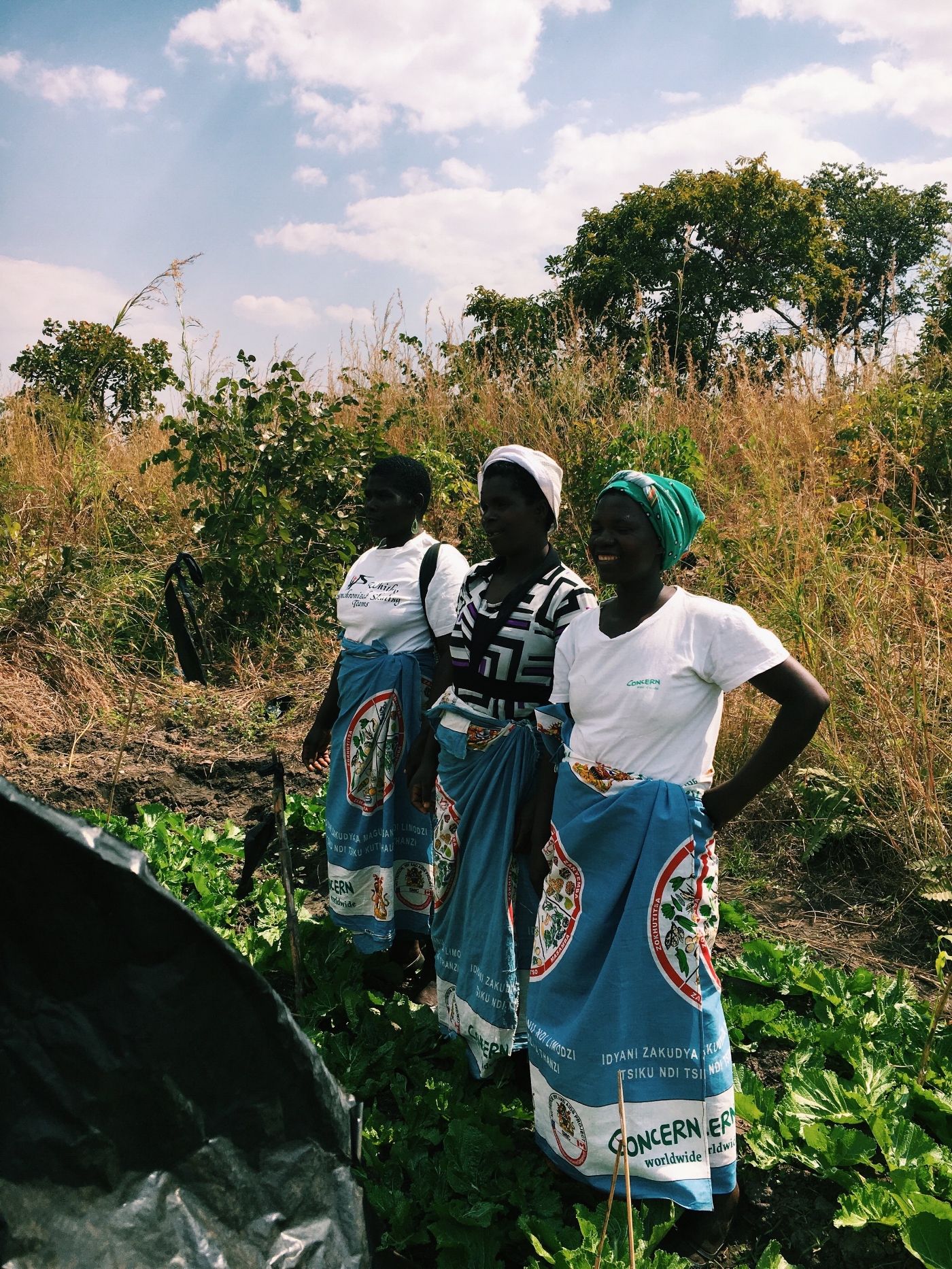 three Lead Mothers stand proudly in their Kitchen Garden, Mchinji District 