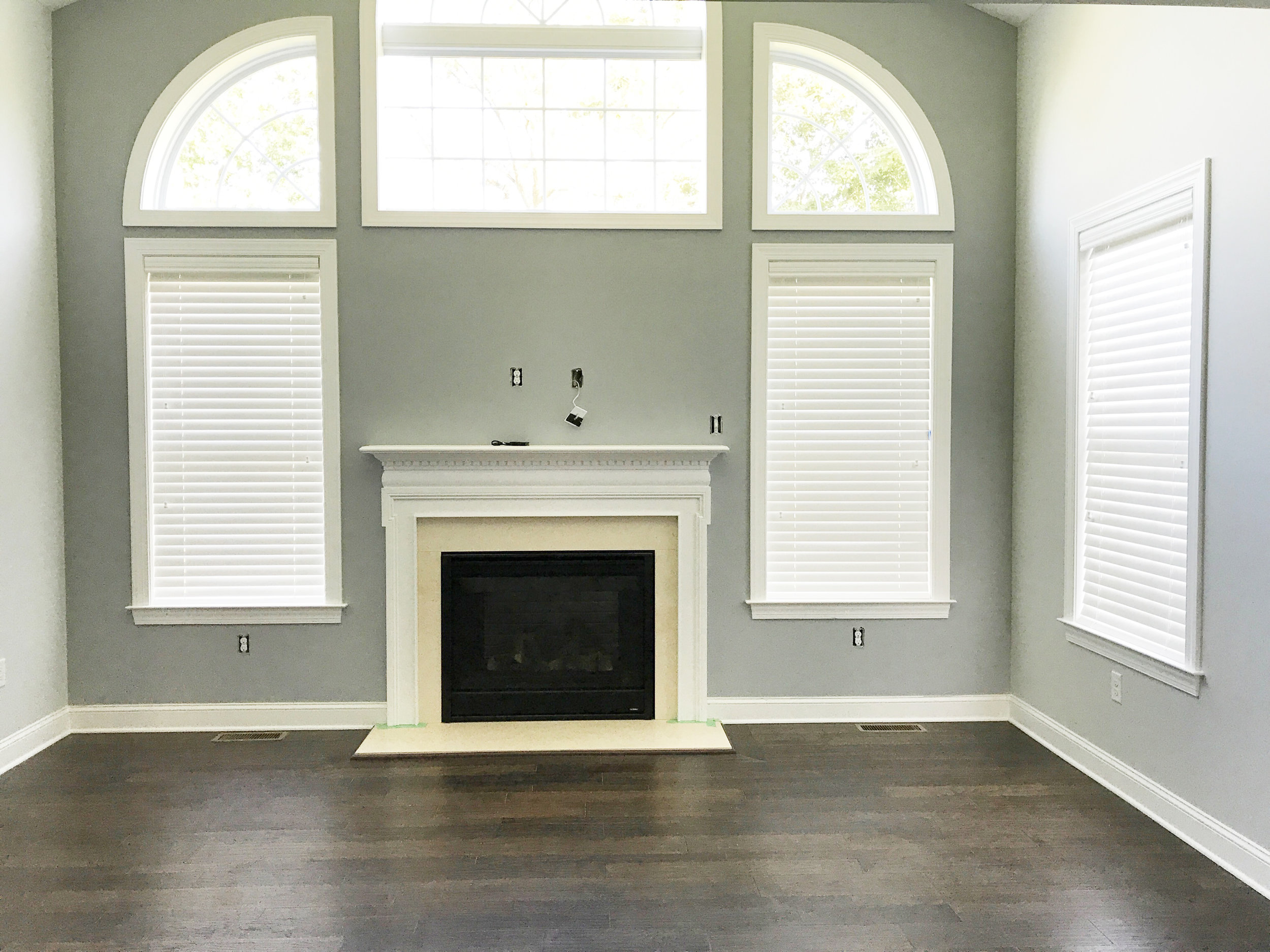 Custom window blinds surrounding fireplace in living room by 3rdGenBlinds