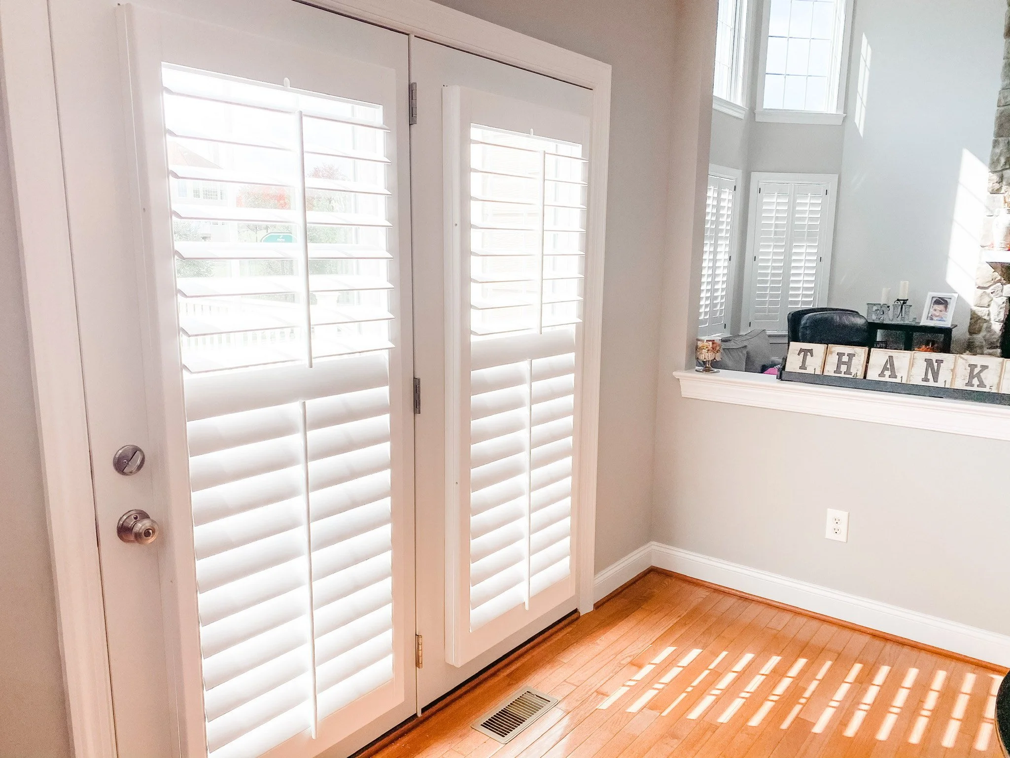 Plantation shutters on door, allowing sunlight to filter through the room