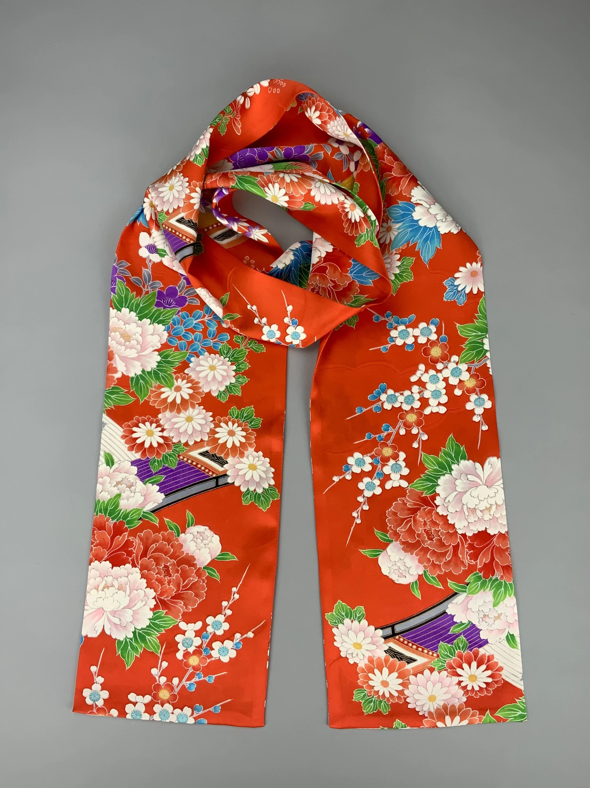 A flatlay of orange scarf with blossom print made from rinzu kimono silk by Kirsty Chivers