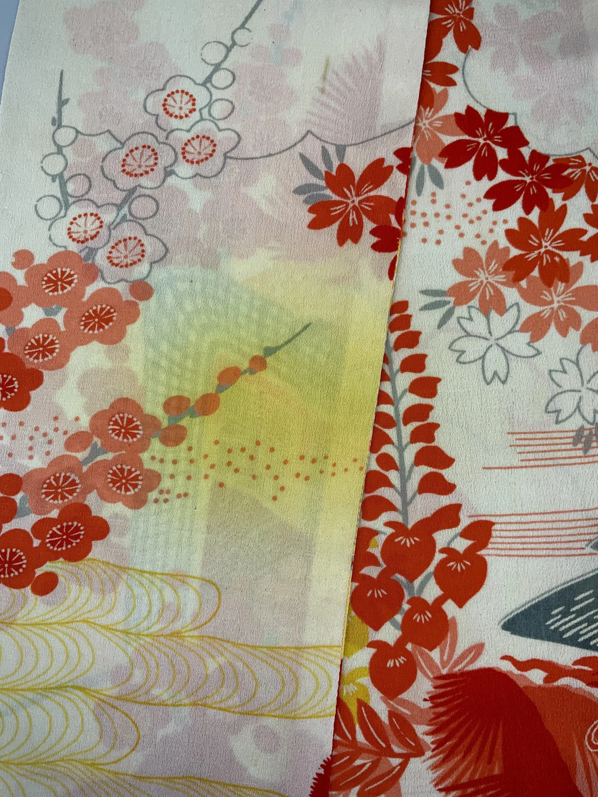 Closeup of vibrant red and yellow scarf with printed blossom design, handmade from repurposed Japanese kimono crepe silk by Kirsty Chivers