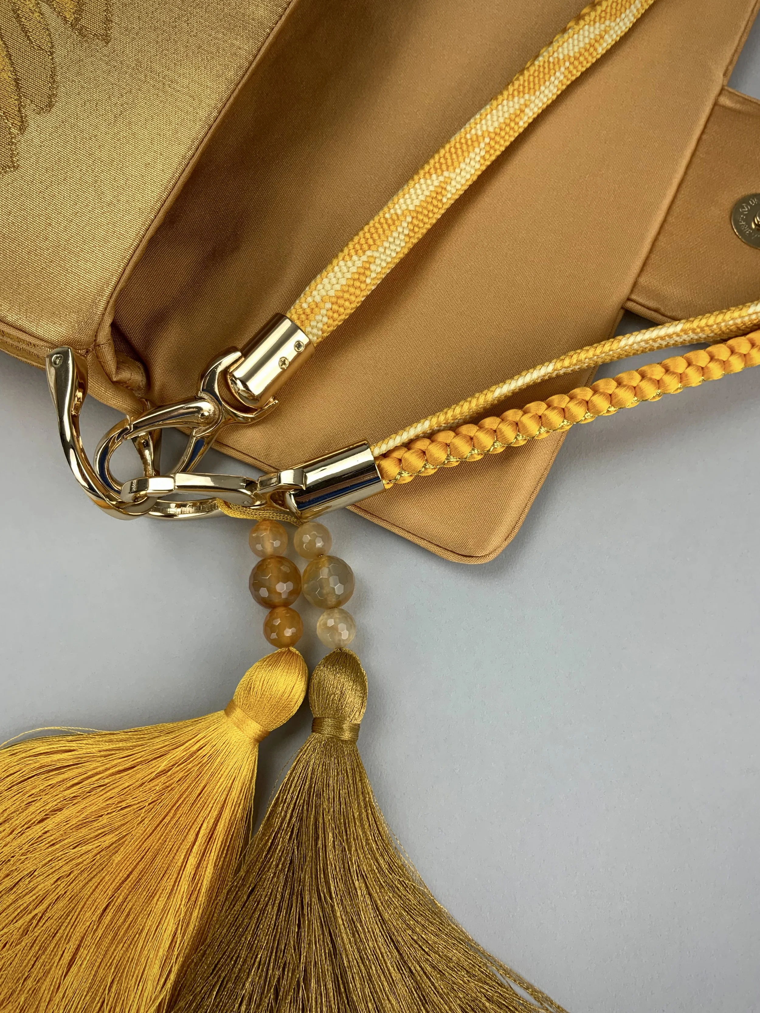 Closeup of lustrous metallic gold baguette evening bag made from vintage Japanese obi silk by Kirsty Chivers
