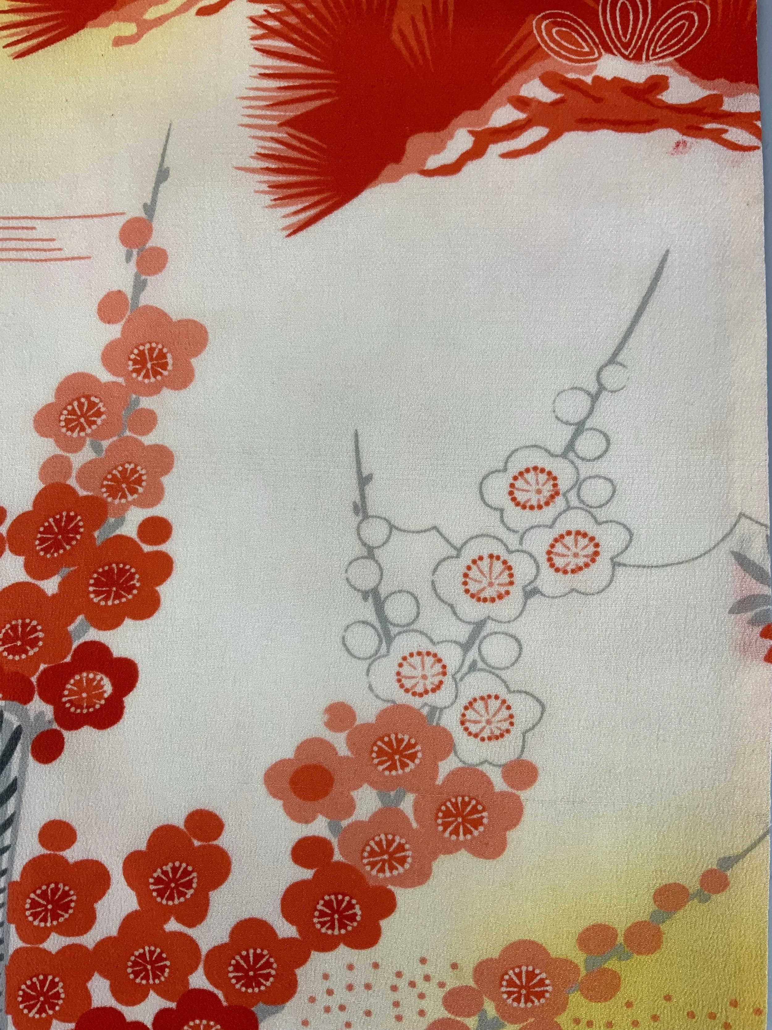 Closeup of vibrant red and yellow scarf with printed blossom design, handmade from repurposed Japanese kimono crepe silk by Kirsty Chivers