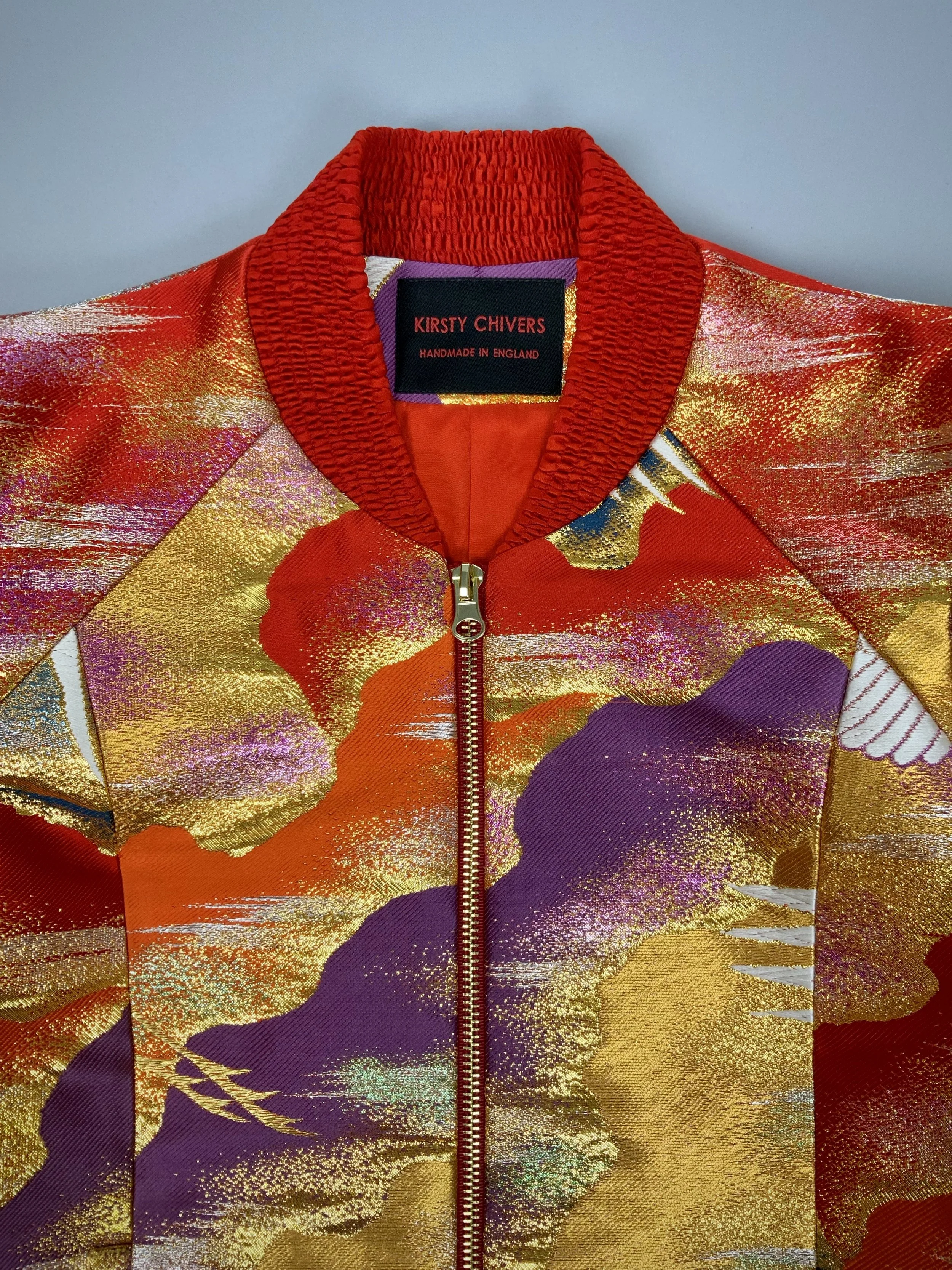 Closeup of one-of-a-kind vermillion red bomber jacket crafted from vintage Japanese kimono silk