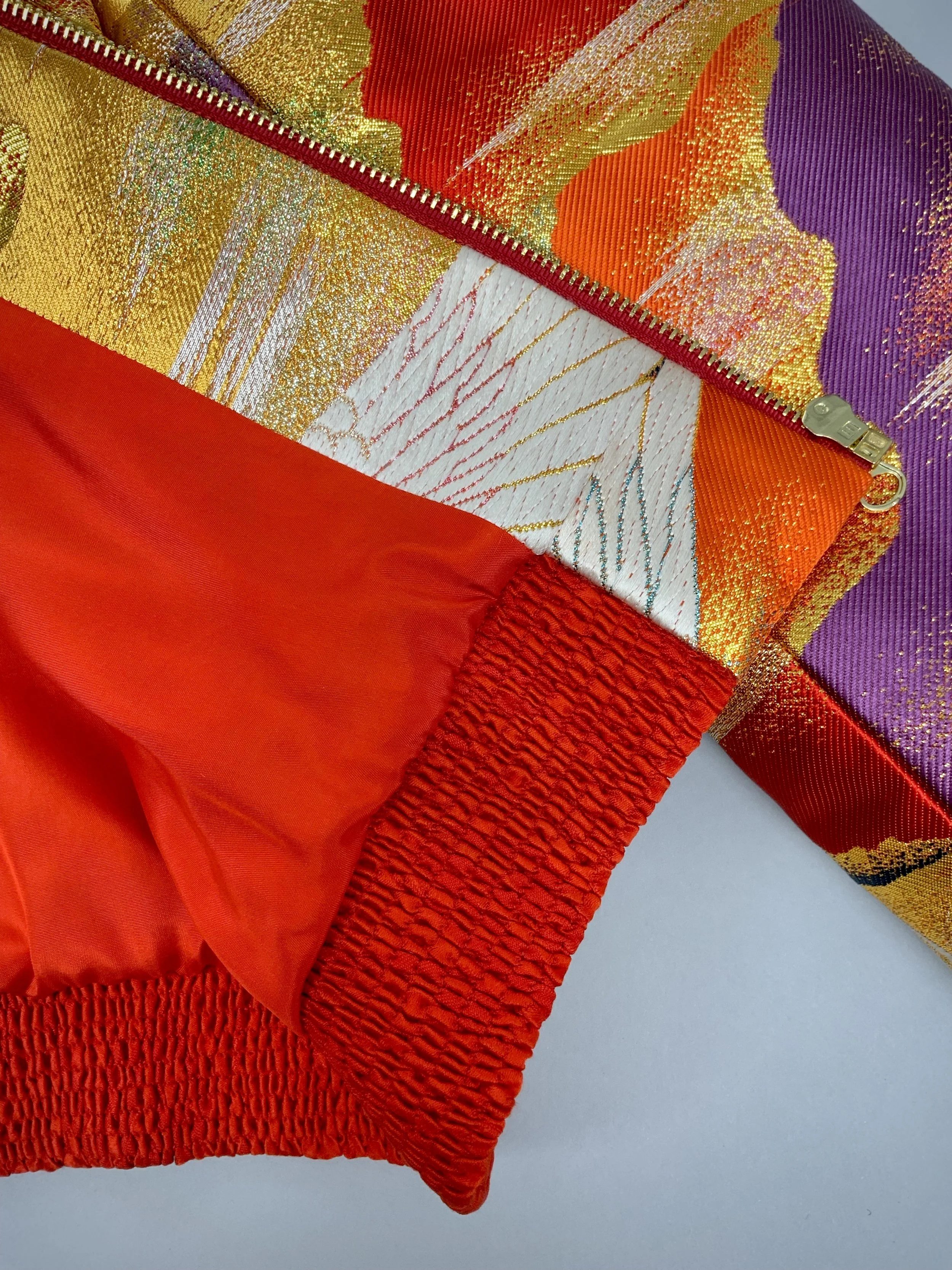Close up of one-of-a-kind vermillion red bomber jacket crafted from vintage Japanese kimono silk
