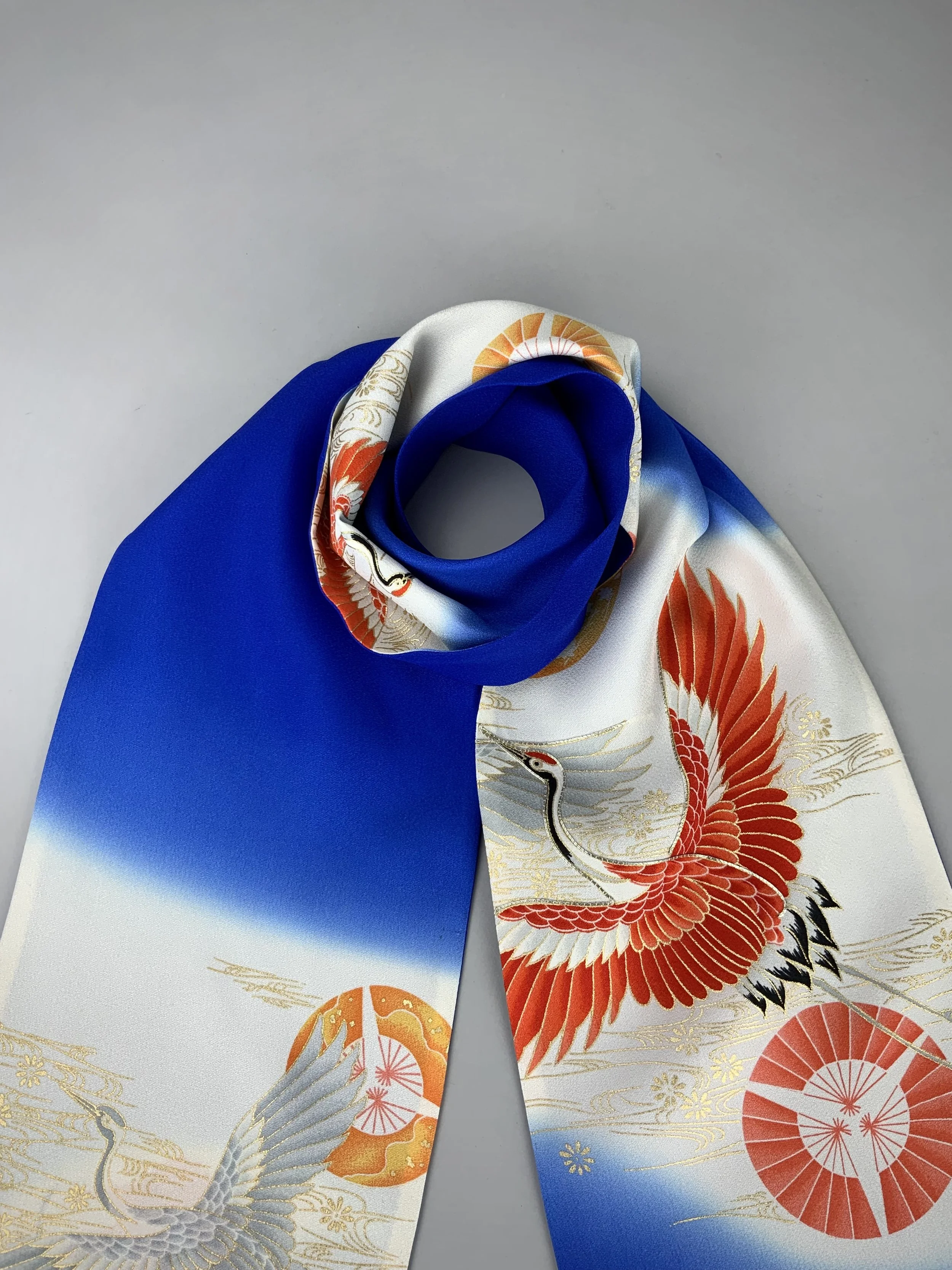 Closeup of blue silk scarf with printed Flying Crane design handmade by Kirsty Chivers