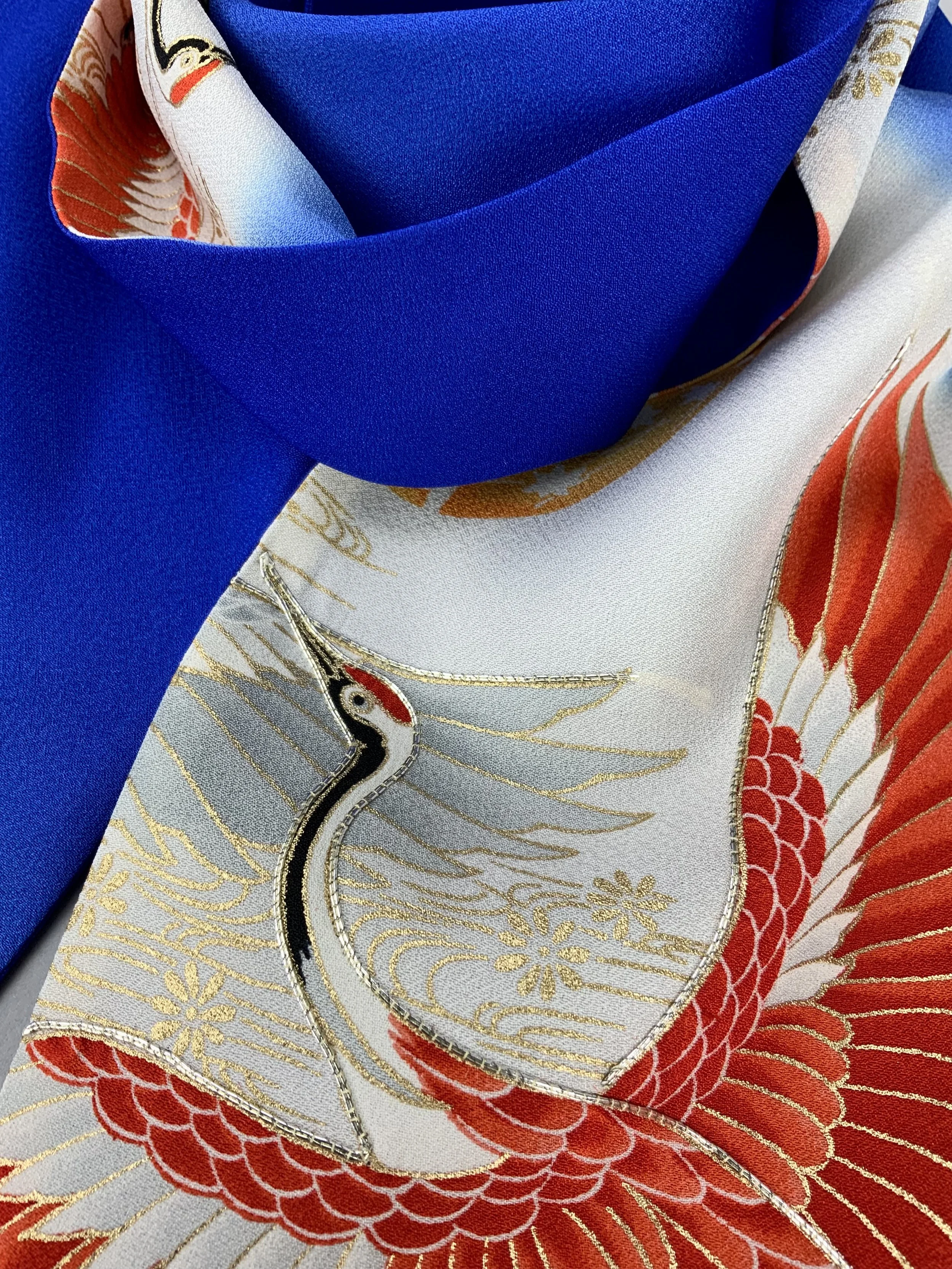 Closeup of blue silk scarf with printed Flying Crane design handmade by Kirsty Chivers