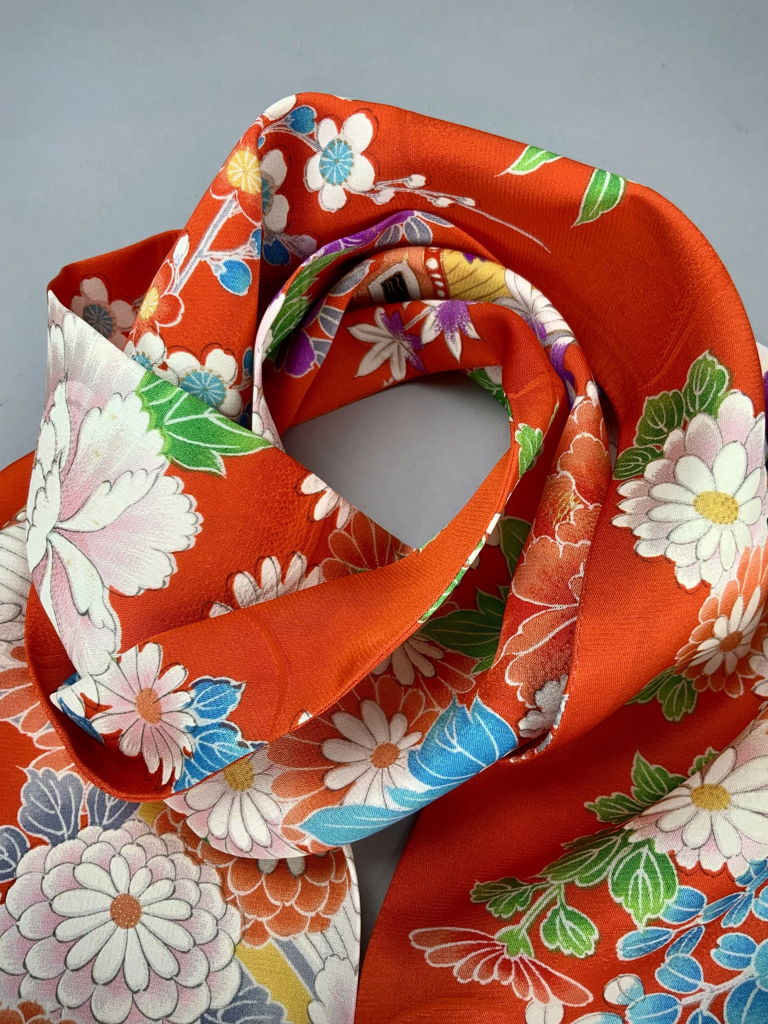 Closeup of orange scarf with blossom print made from rinzu kimono silk by Kirsty Chivers