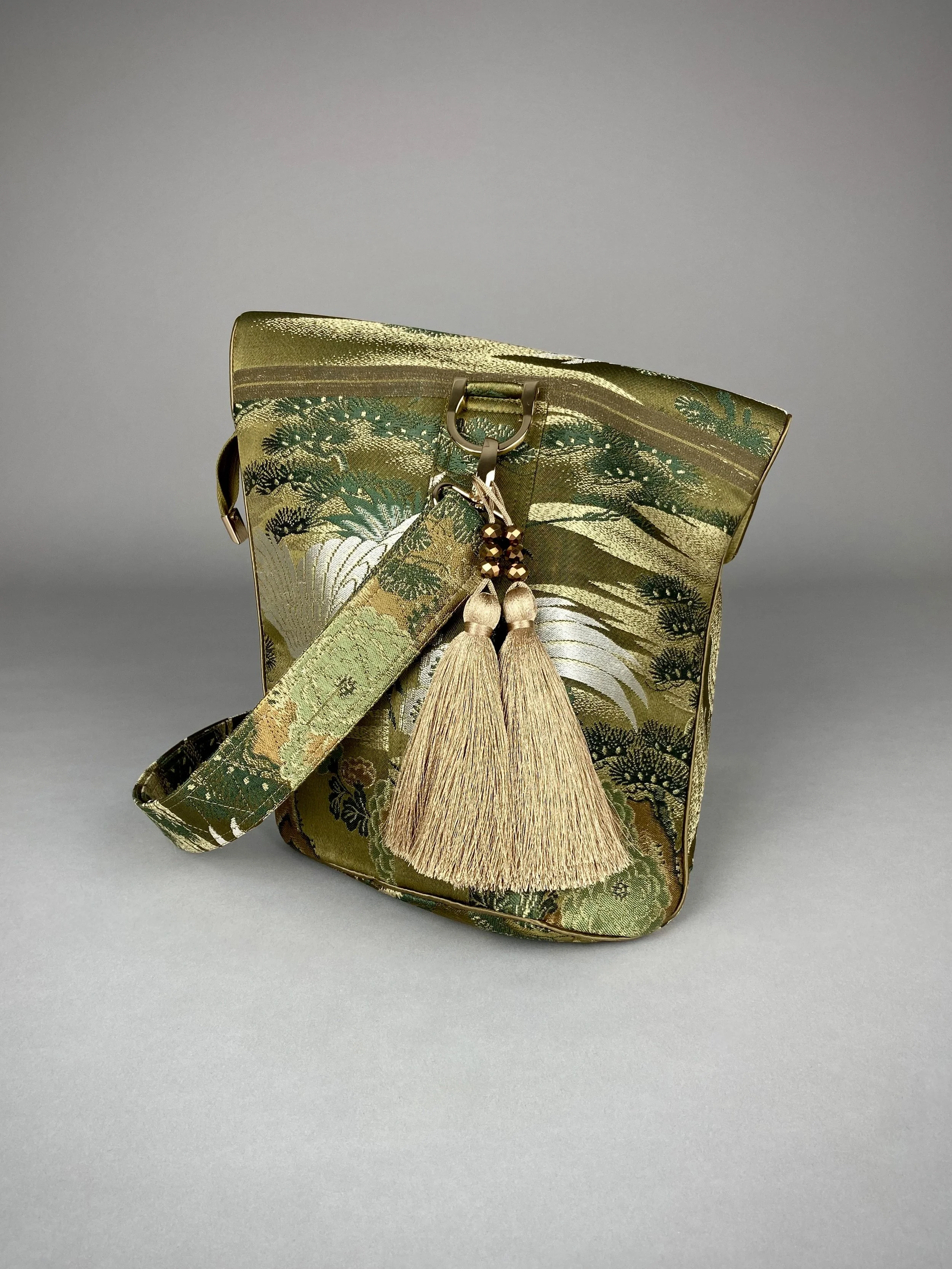 Green and gold vintage obi silk shoulder bag with crane, pine and chrysanthemum design, gold hardware and matching fabric tassel charm by Kirsty Chivers