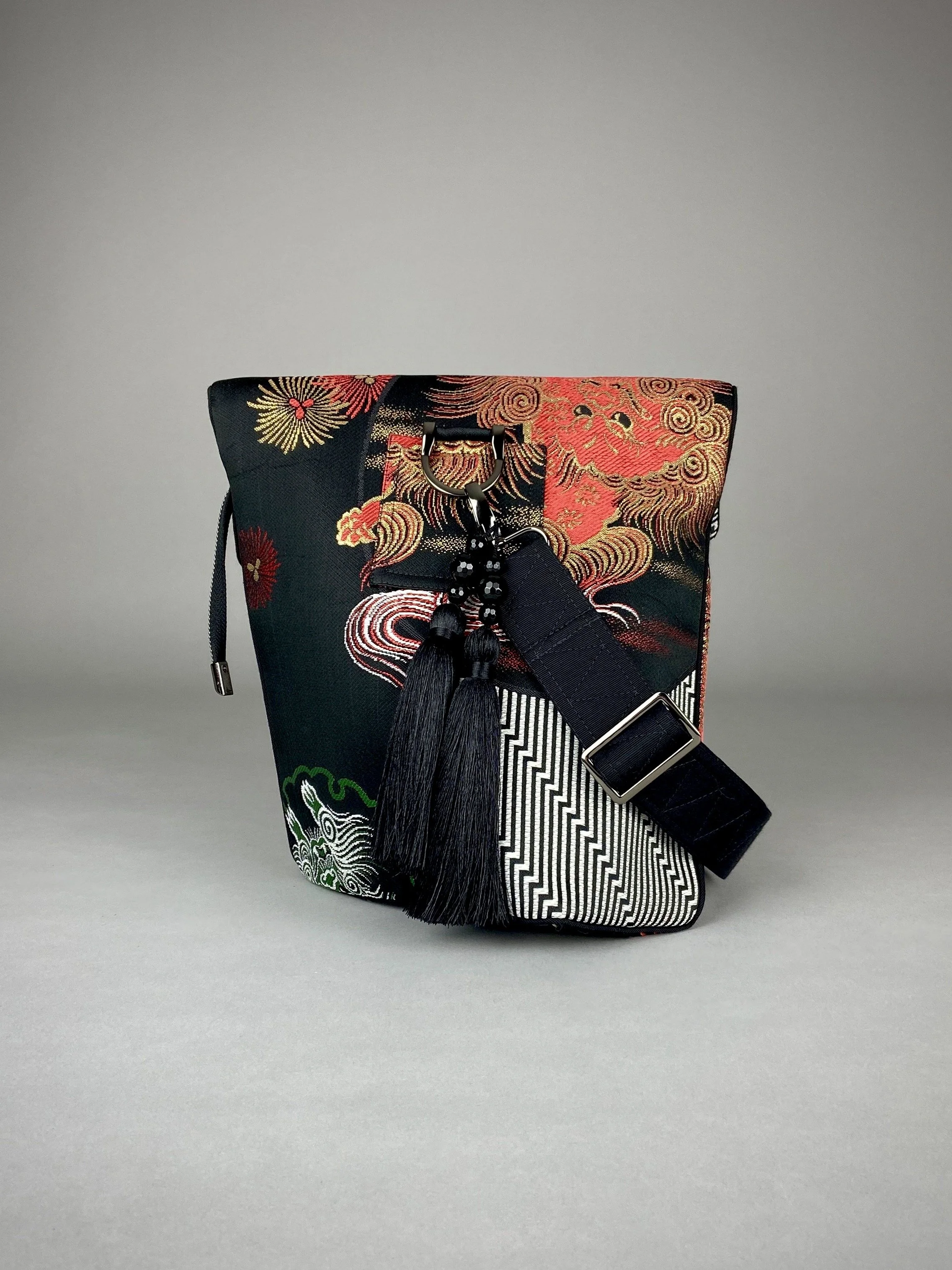 Black matt satin silk and rayon obi bag with red, green, gold and ivory dragon motifs, gunmetal hardware and black tassel charm by Kirsty Chivers