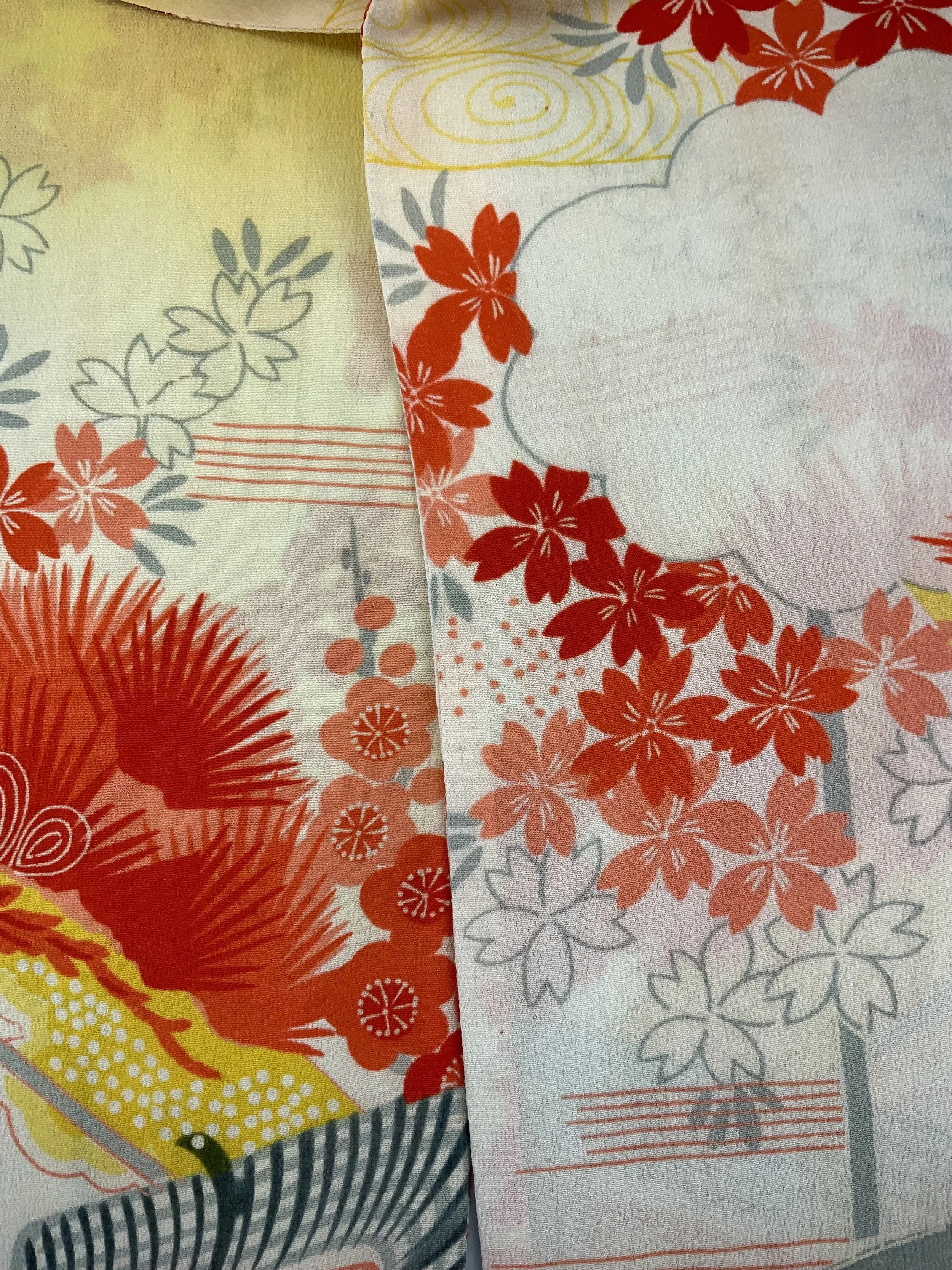 Closeup of vibrant red and yellow scarf with printed blossom design, handmade from repurposed Japanese kimono crepe silk by Kirsty Chivers