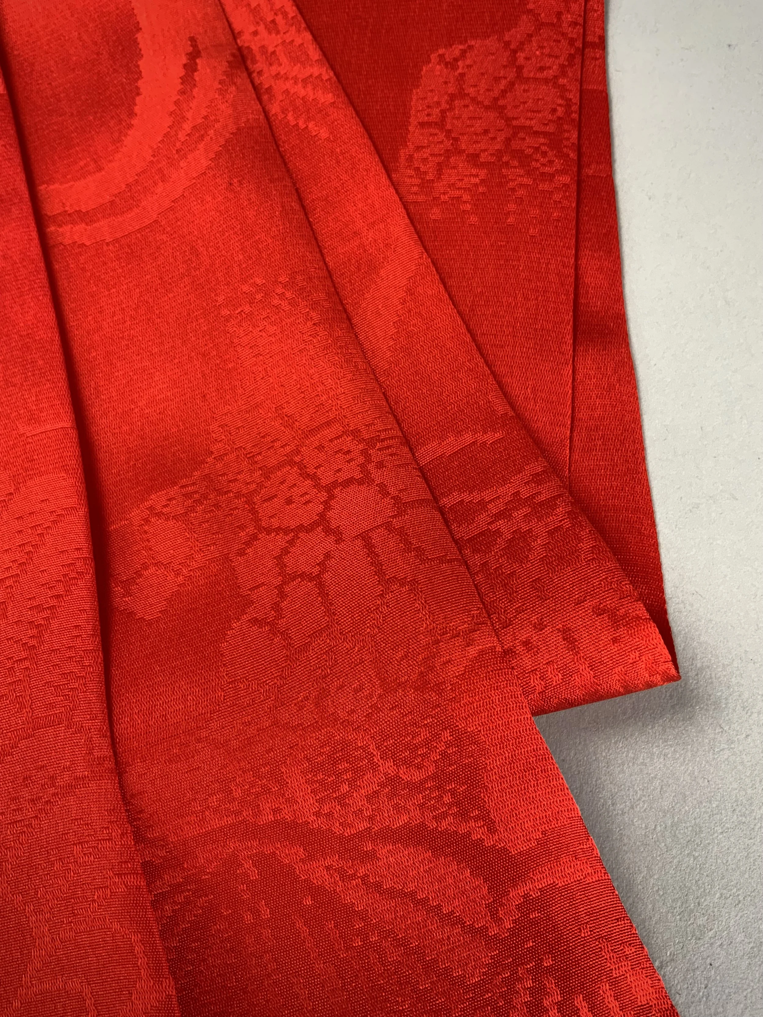 Flatlay of a vibrant vermillion red silk scarf crafted from kimono silk by Kirsty Chivers Handmade