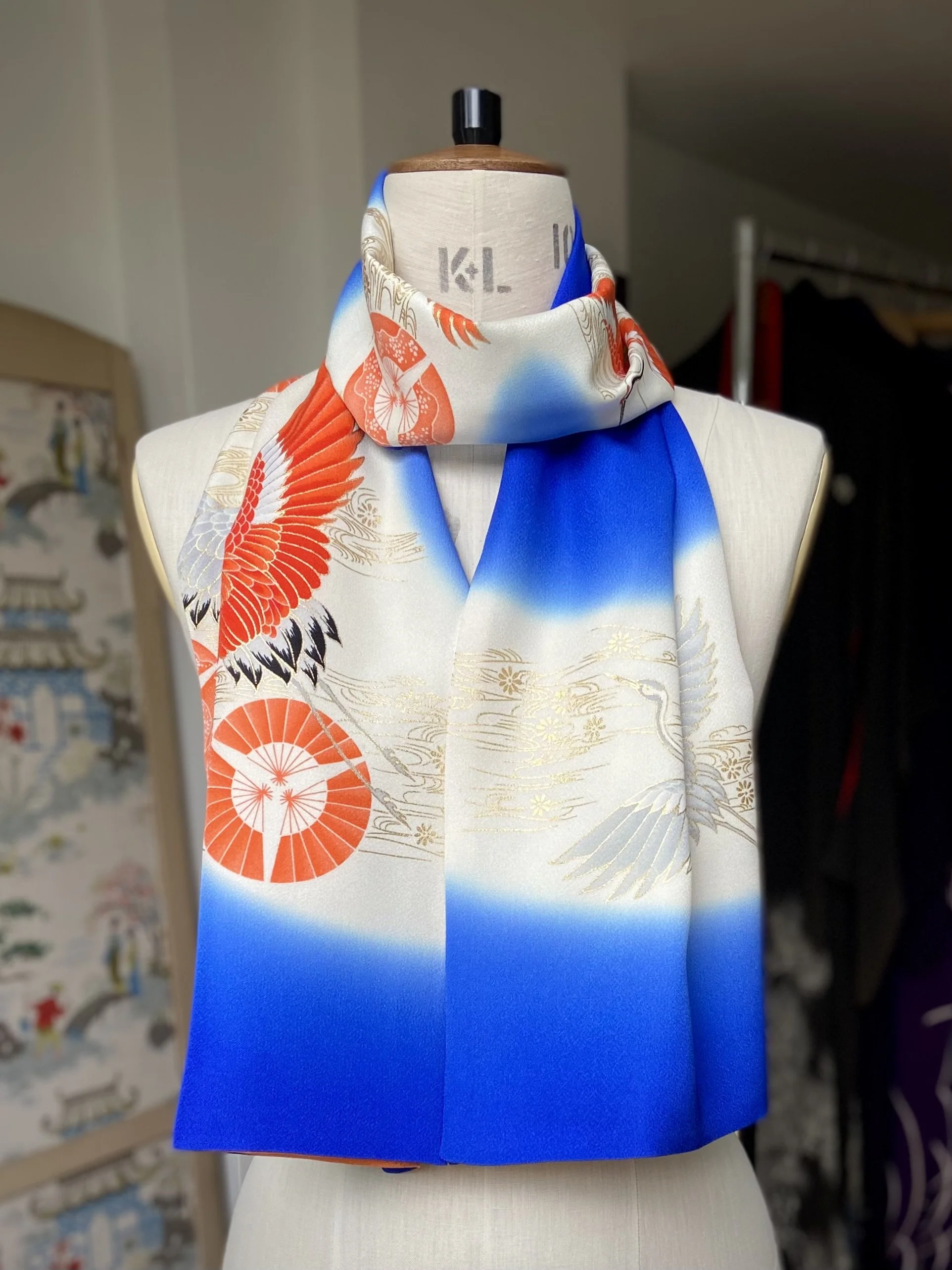 Blue silk scarf, presented on a dress stand, with printed Flying Crane design handmade by Kirsty Chivers