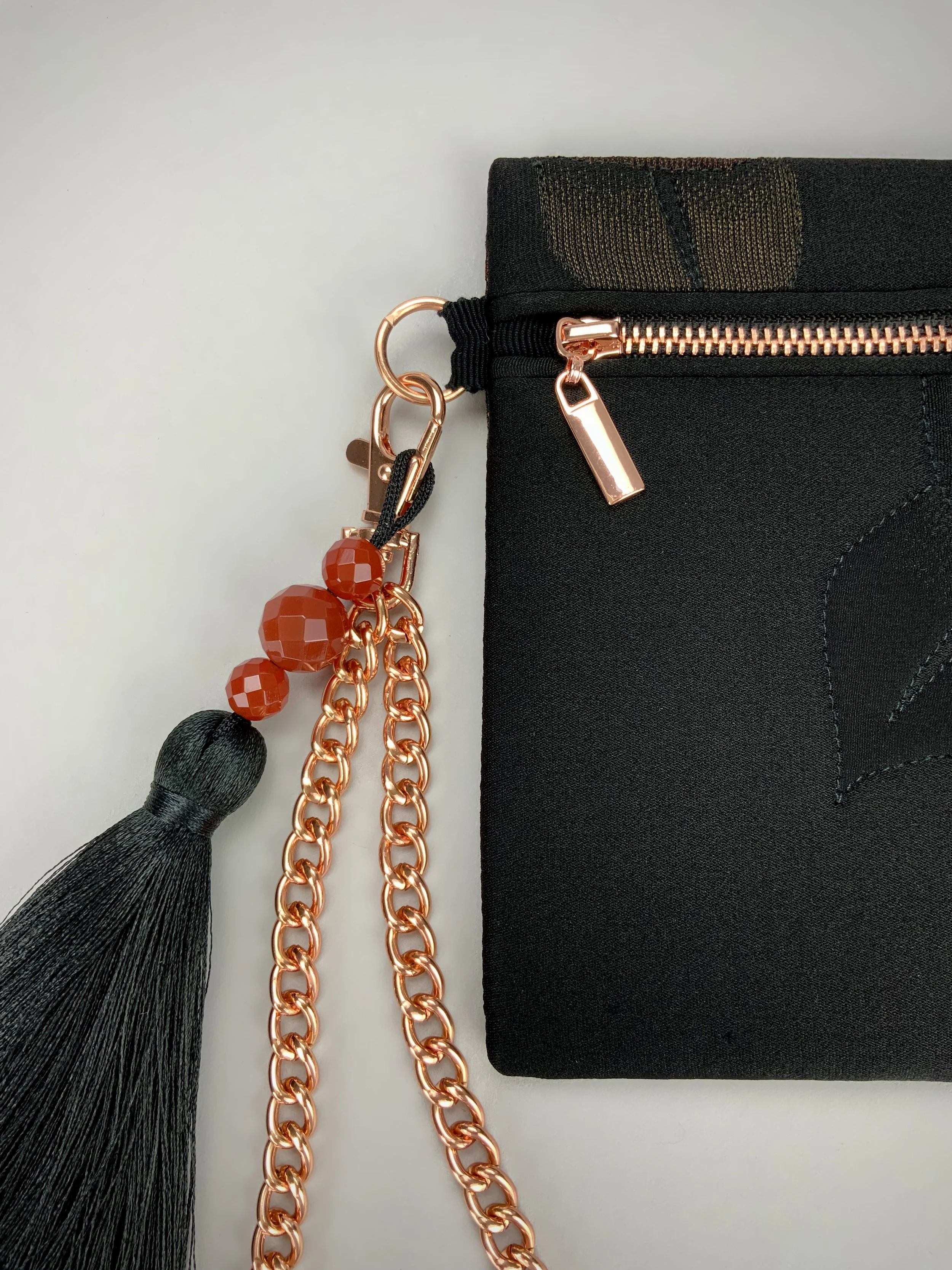 Closeup of black quilted clutch purse with tassel & Carnelian beads, made from vintage Japanese kimono silk