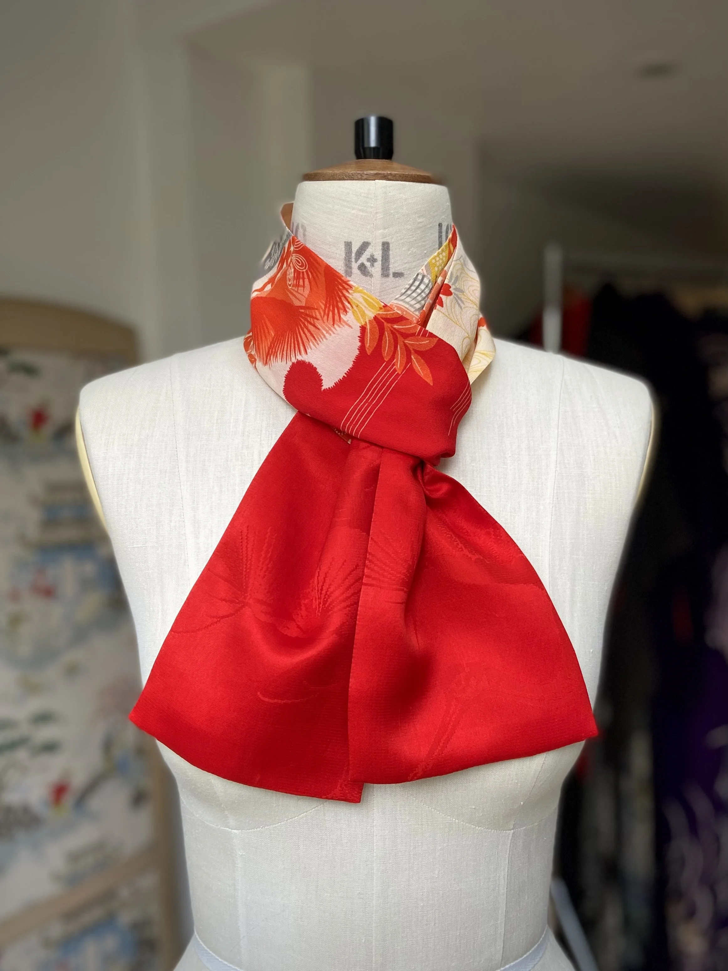 Bright red and yellow scarf presented on a dress stand, with printed blossom design, handmade from repurposed Japanese kimono crepe silk by Kirsty Chivers