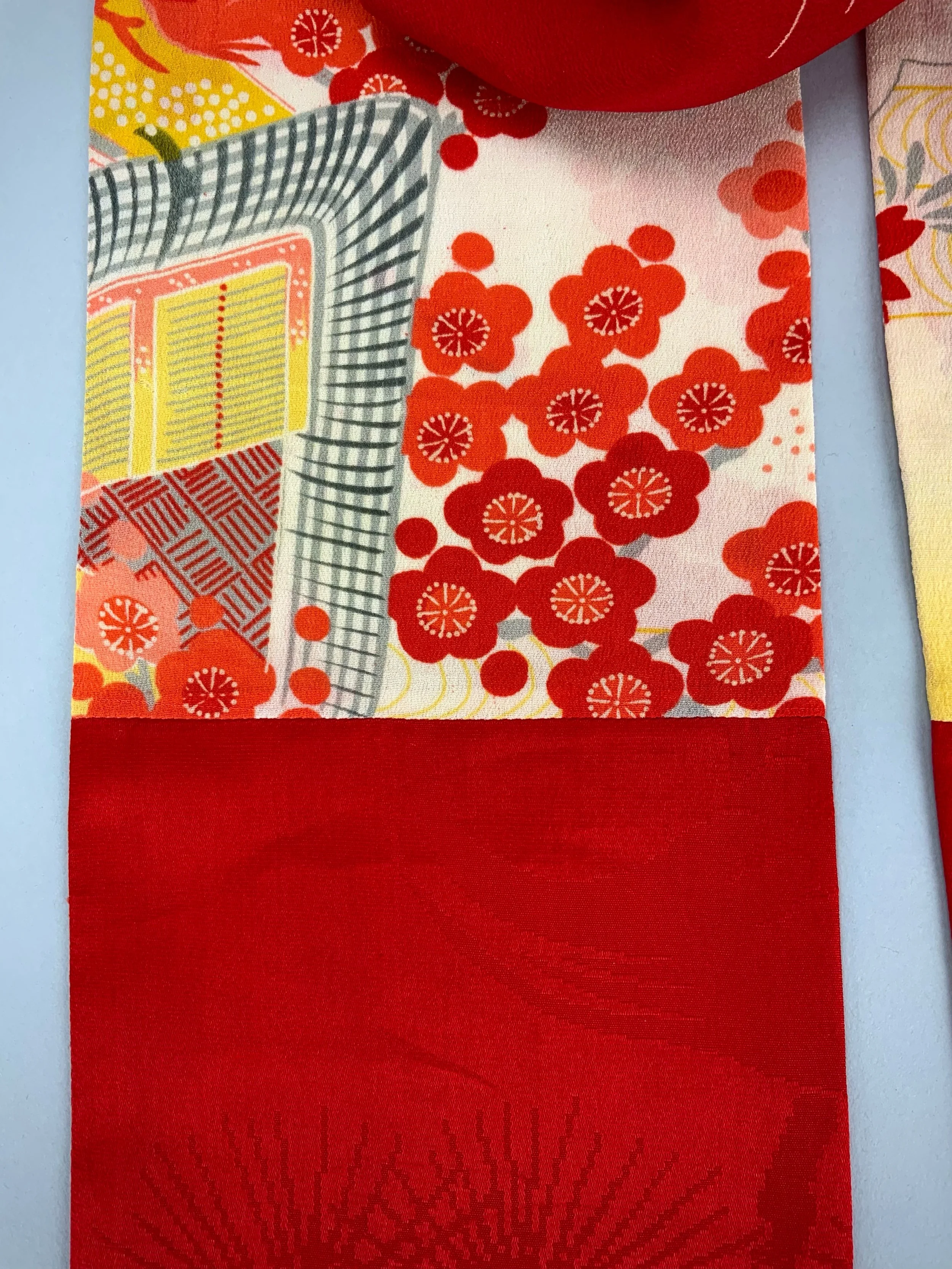 Closeup of vibrant red and yellow scarf with printed blossom design, handmade from repurposed Japanese kimono crepe silk by Kirsty Chivers