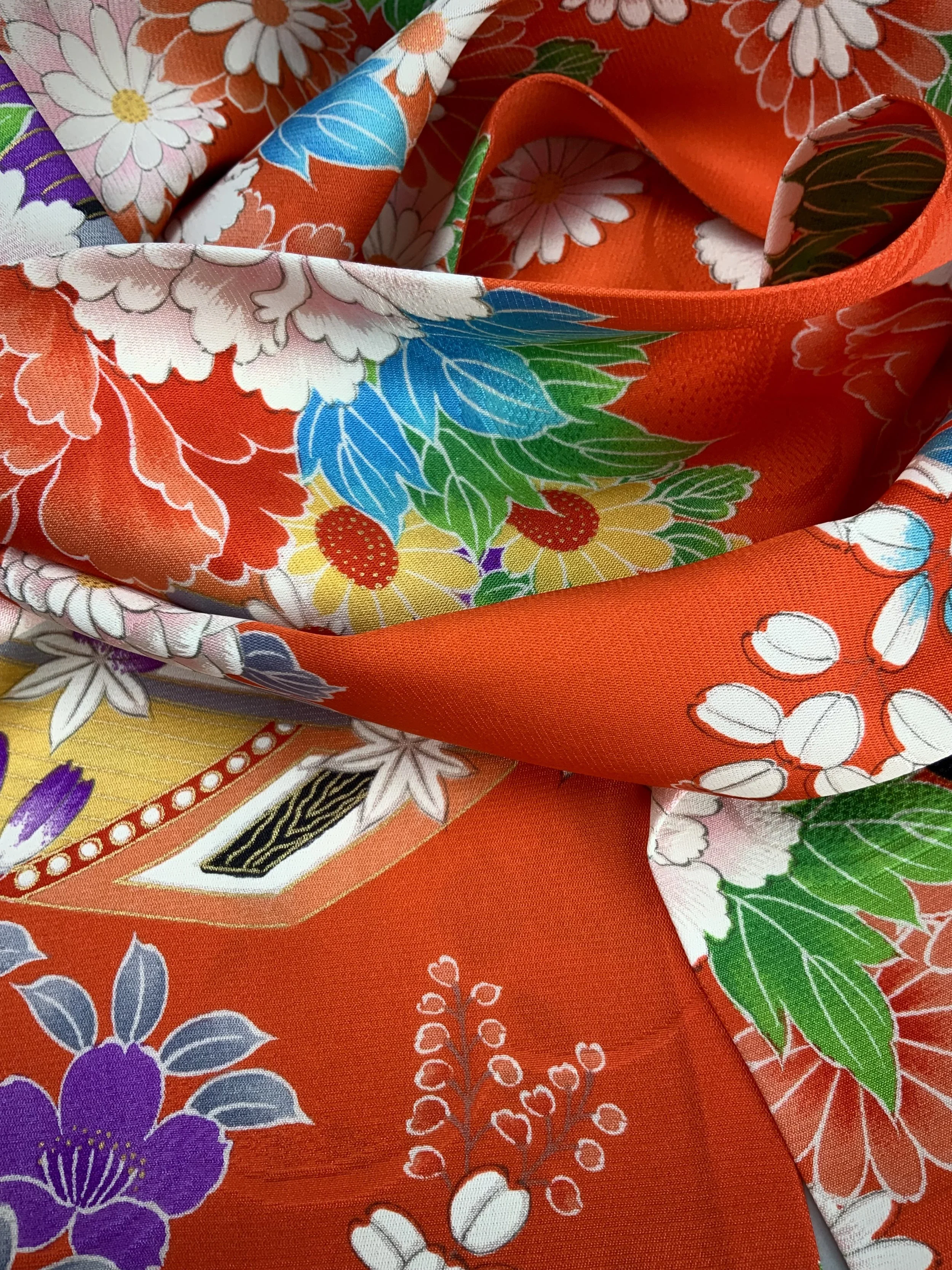 Closeup of orange scarf with blossom print made from rinzu kimono silk by Kirsty Chivers