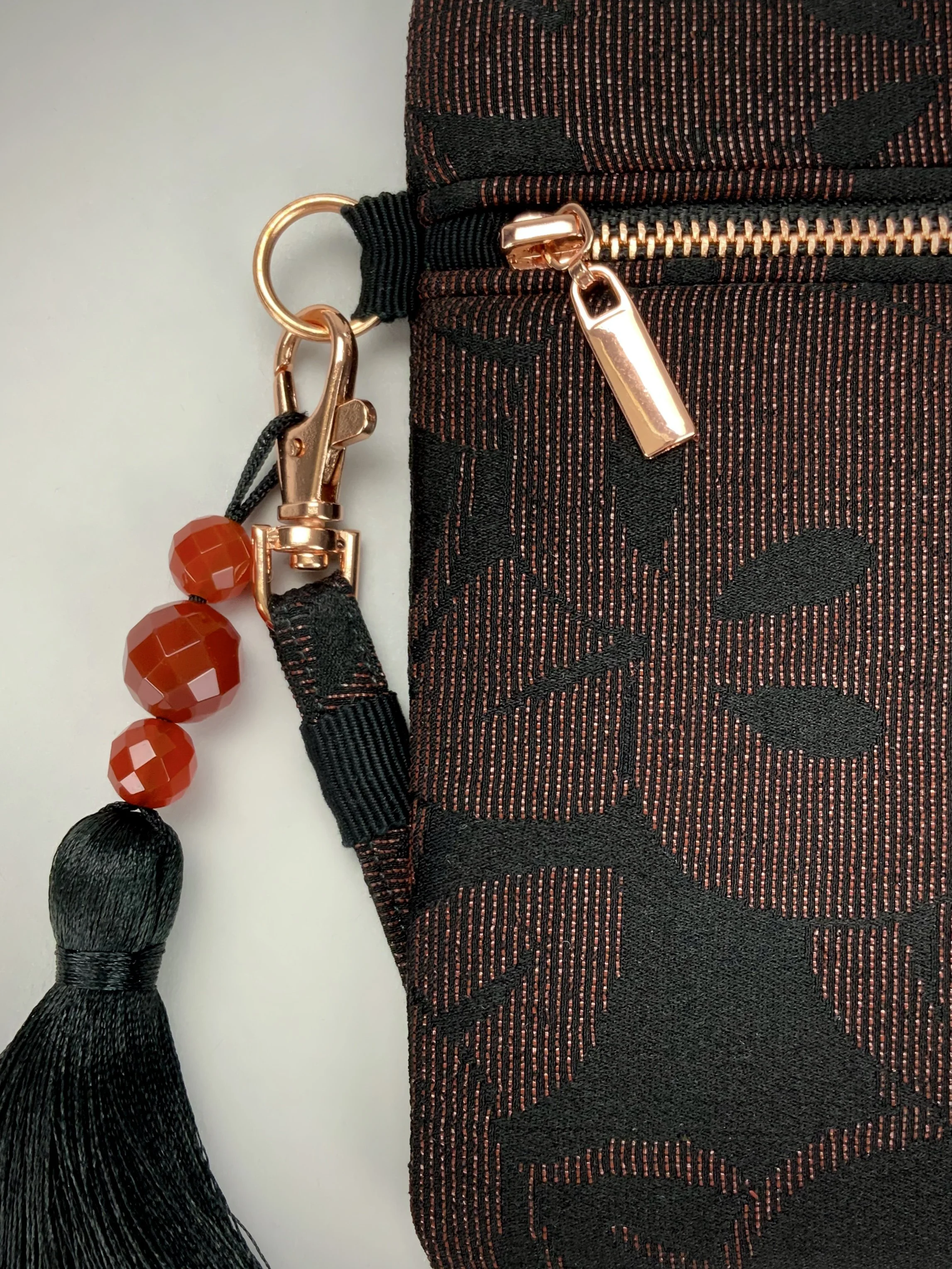 Closeup of glittery black evening clutch with tassel made from vintage Japanese kimono silk