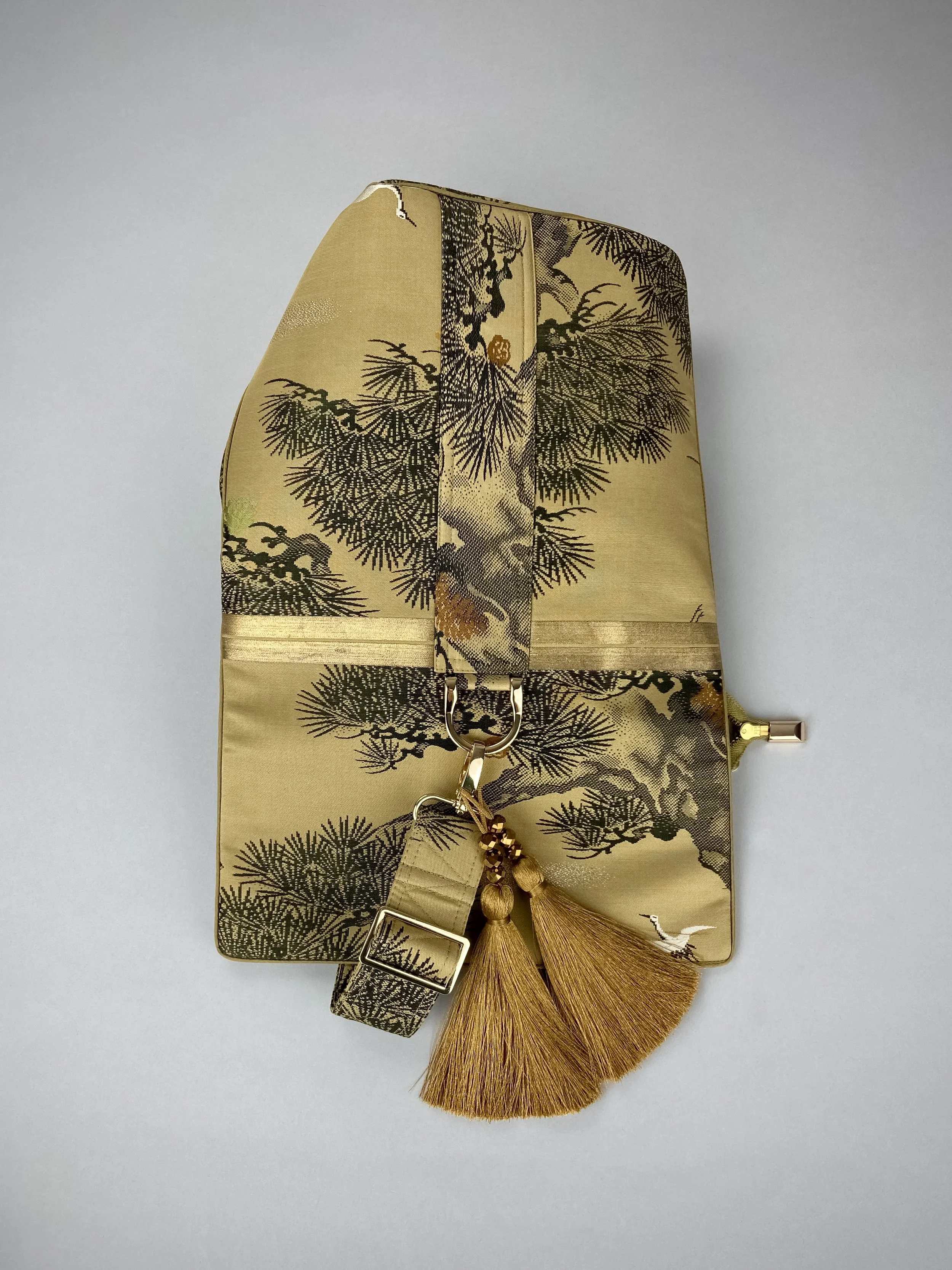 Olive green Matsu pine vintage obi silk shoulder bag with crane design, gold thread detailing and matching fabric tassel charm by Kirsty Chivers