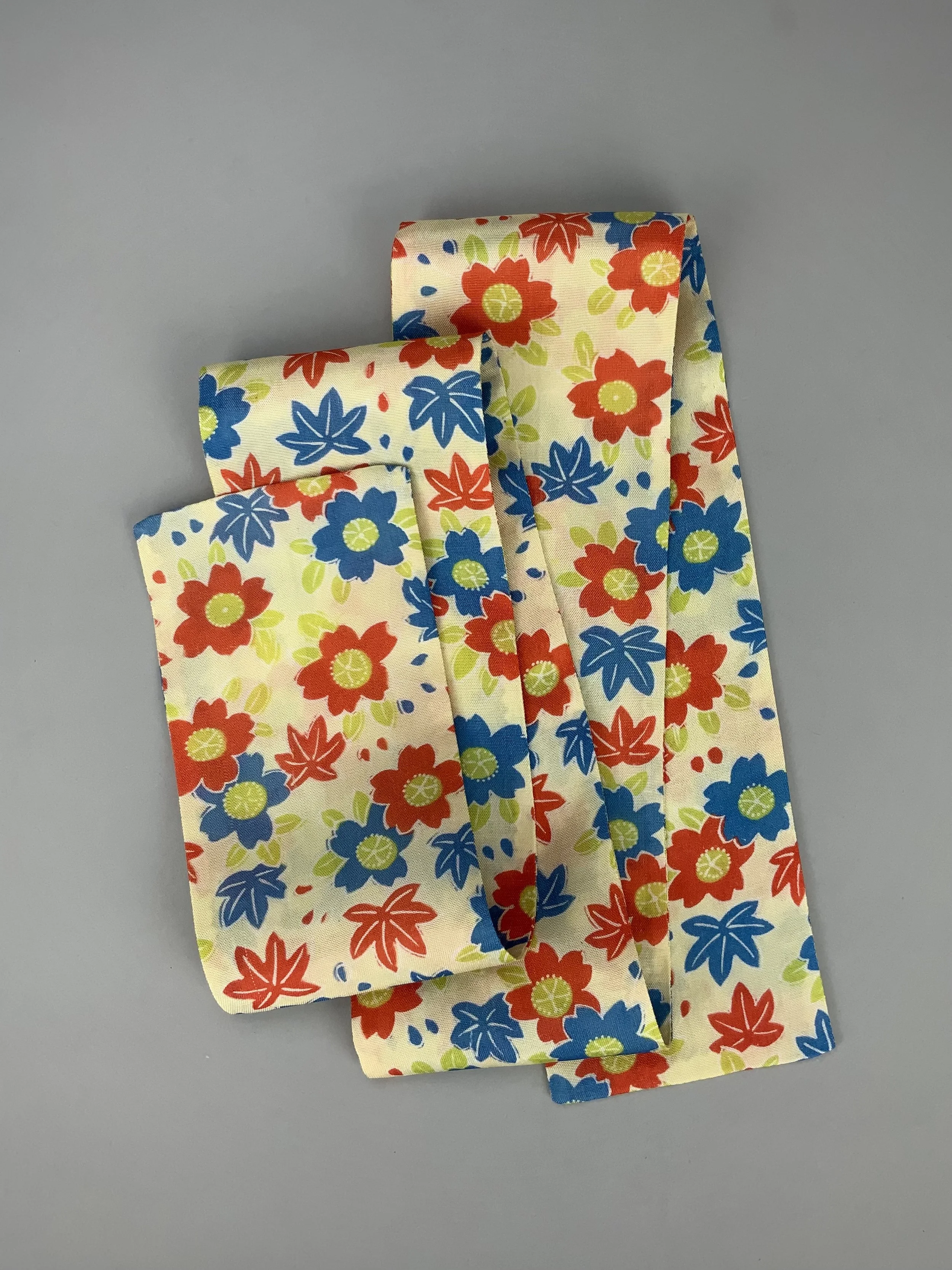 Flatlay of butter yellow skinny scarf with Cherry blossom & Maple leaf print, handmade by Kirsty Chivers