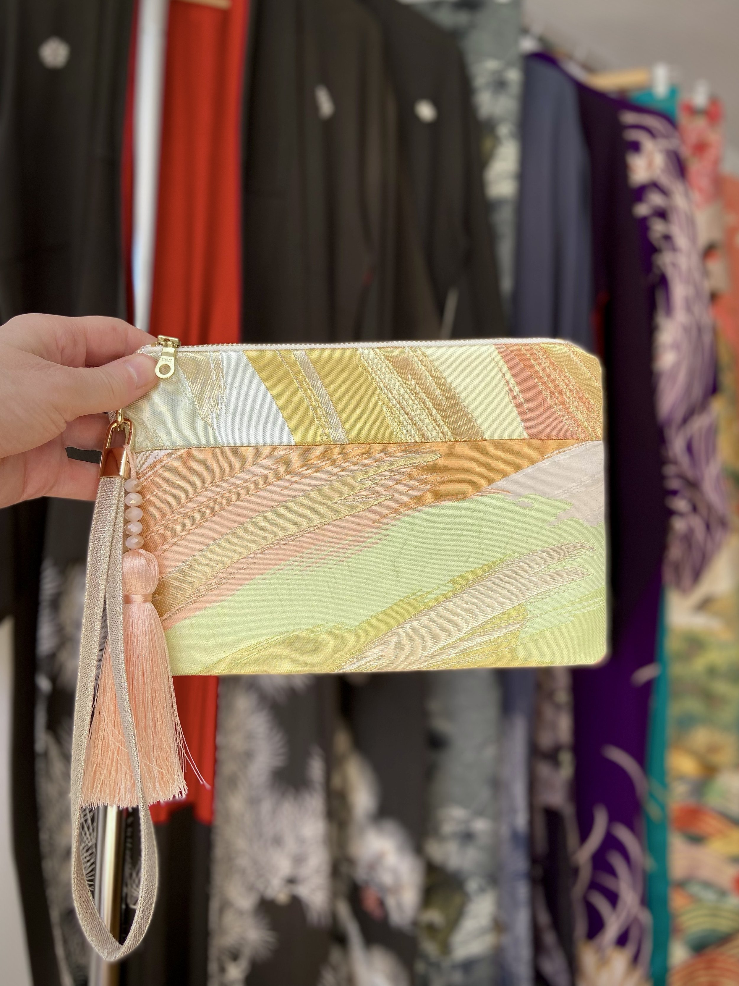 Wristlet purse made from repurposed vintage obi fabric with brushstroke pastel design and gold-silver threads