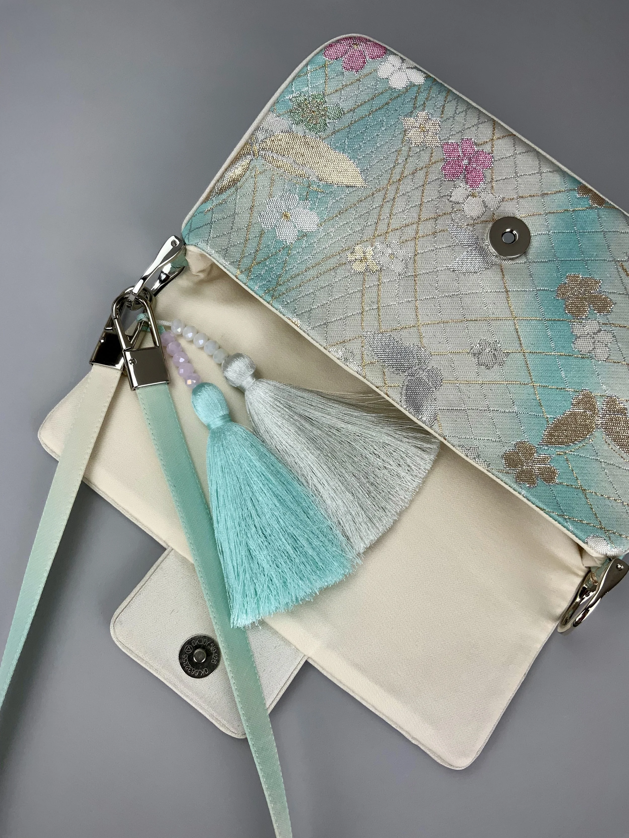 Closeup of aqua ombre evening bag made from vintage obi silk with pastel gold butterfly and blossom design by Kirsty Chivers