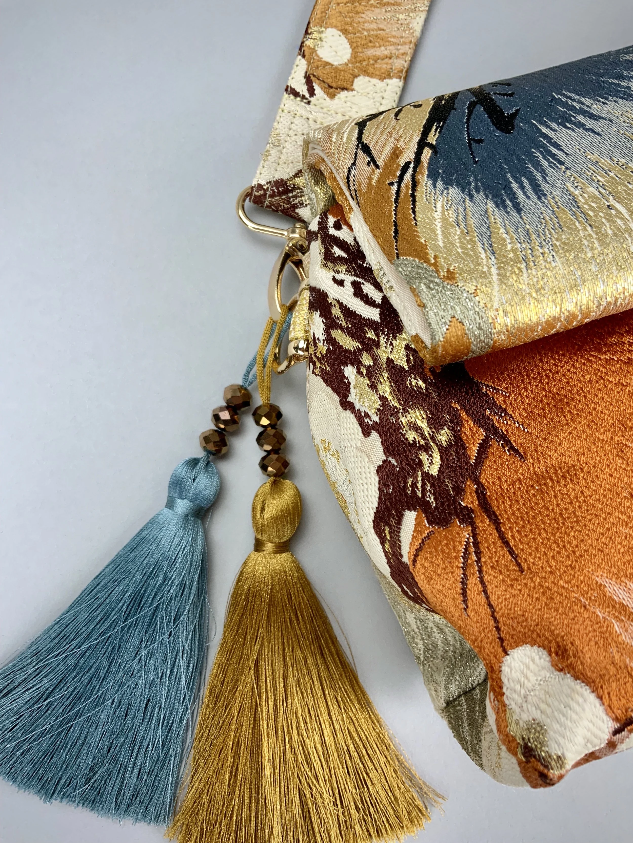 Closeup of metallic gold evening bag with Matsu pine and blossom design, made from vintage obi silk by Kirsty Chivers