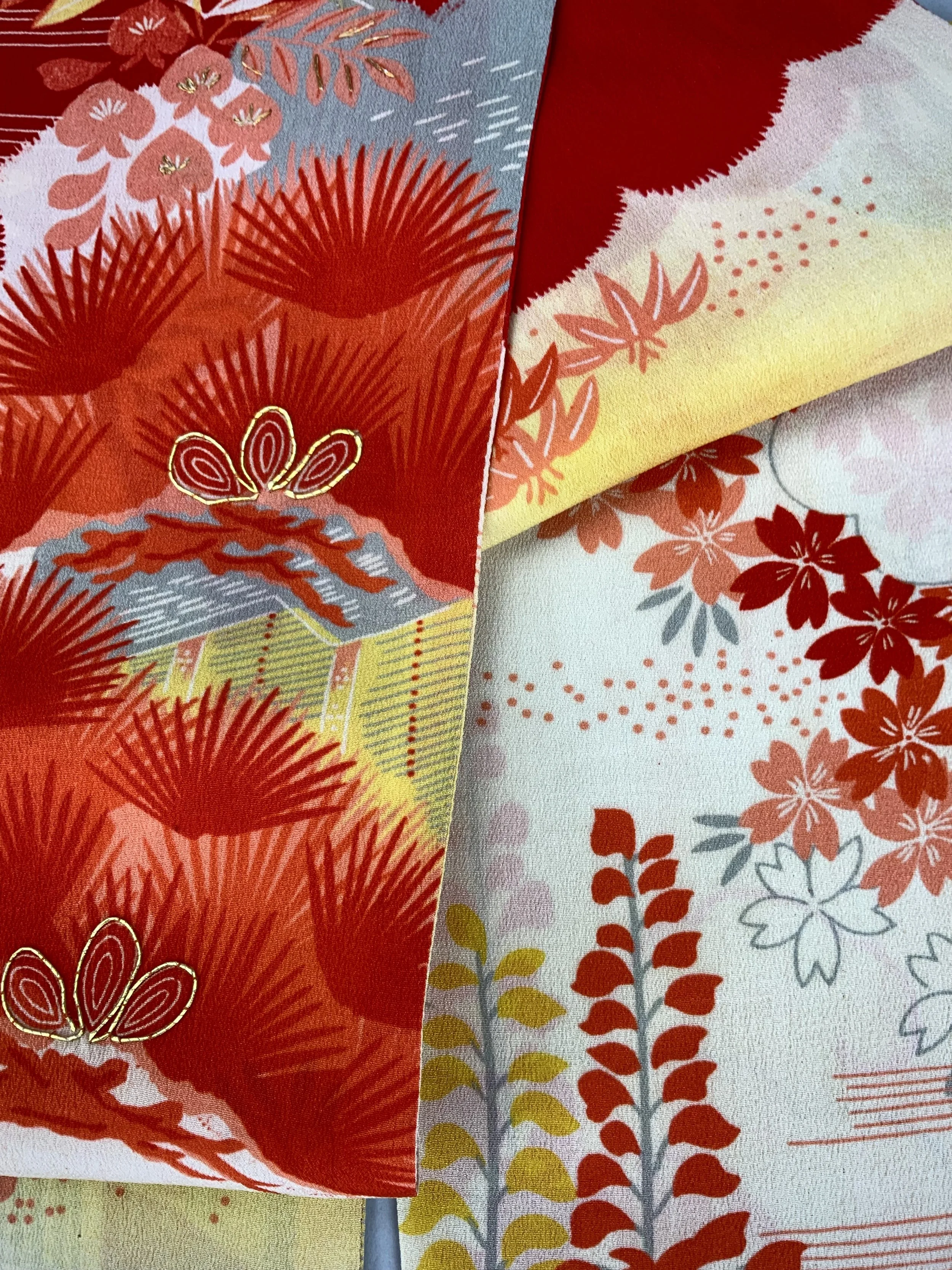 Closeup of vibrant red and yellow scarf with printed blossom design, handmade from repurposed Japanese kimono crepe silk by Kirsty Chivers