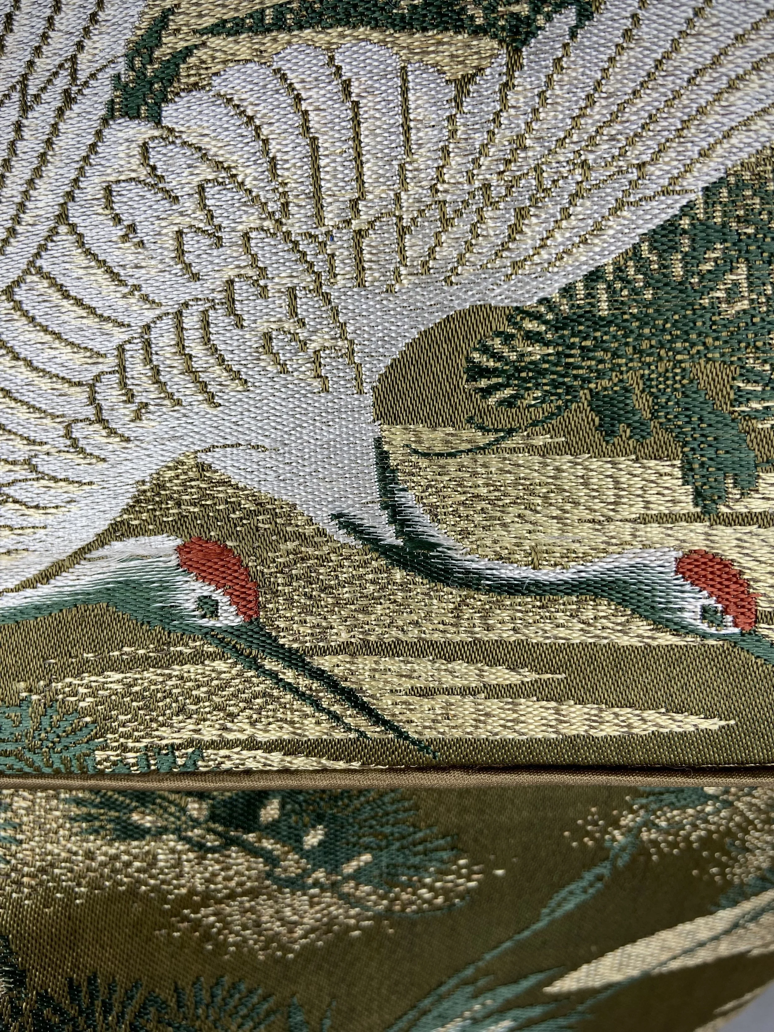 Closeup of green and gold vintage obi silk shoulder bag with crane, pine and chrysanthemum design, gold hardware and matching fabric tassel charm by Kirsty Chivers