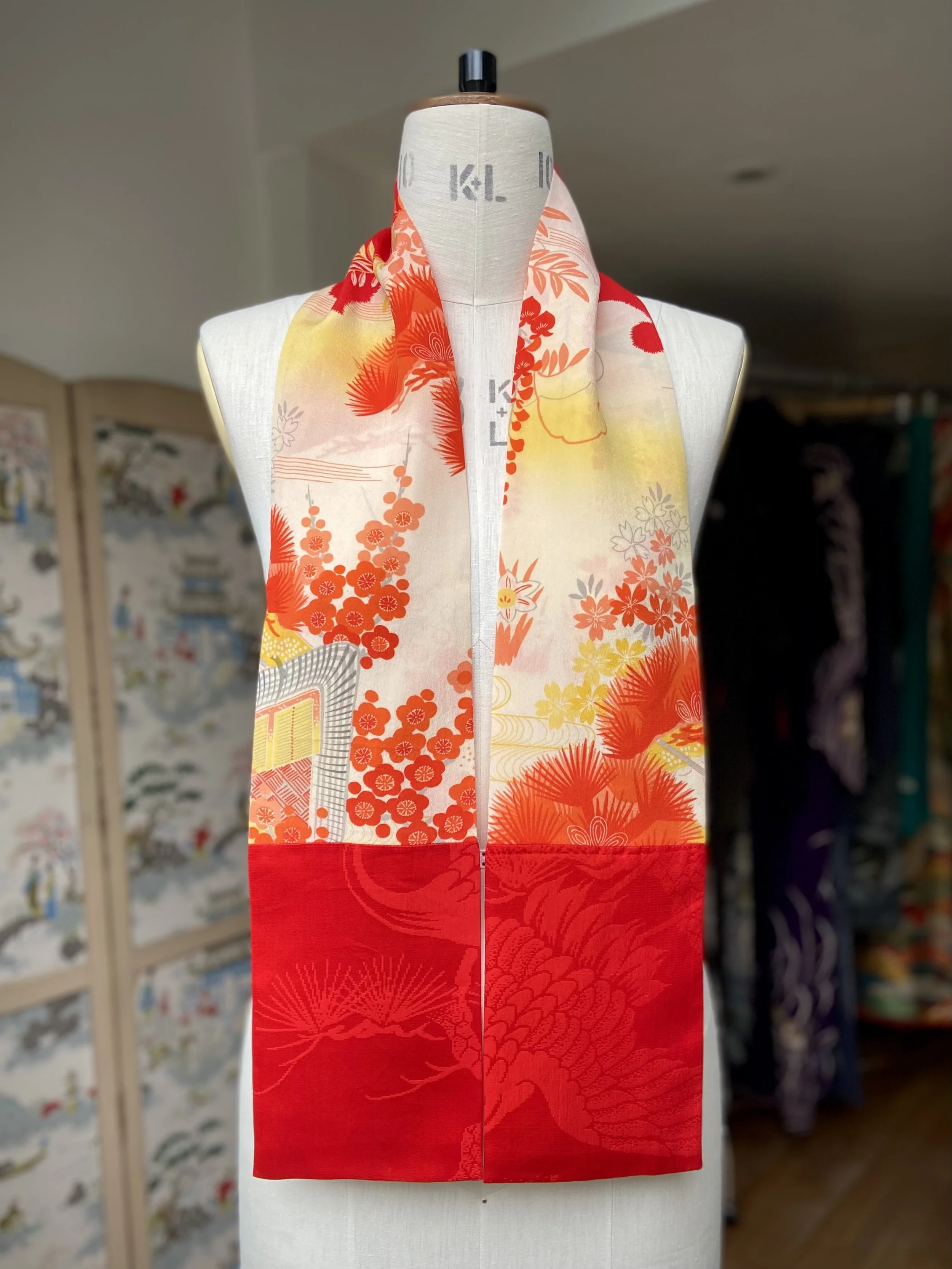 Bright red and yellow scarf presented on a dress stand, with printed blossom design, handmade from repurposed Japanese kimono crepe silk by Kirsty Chivers