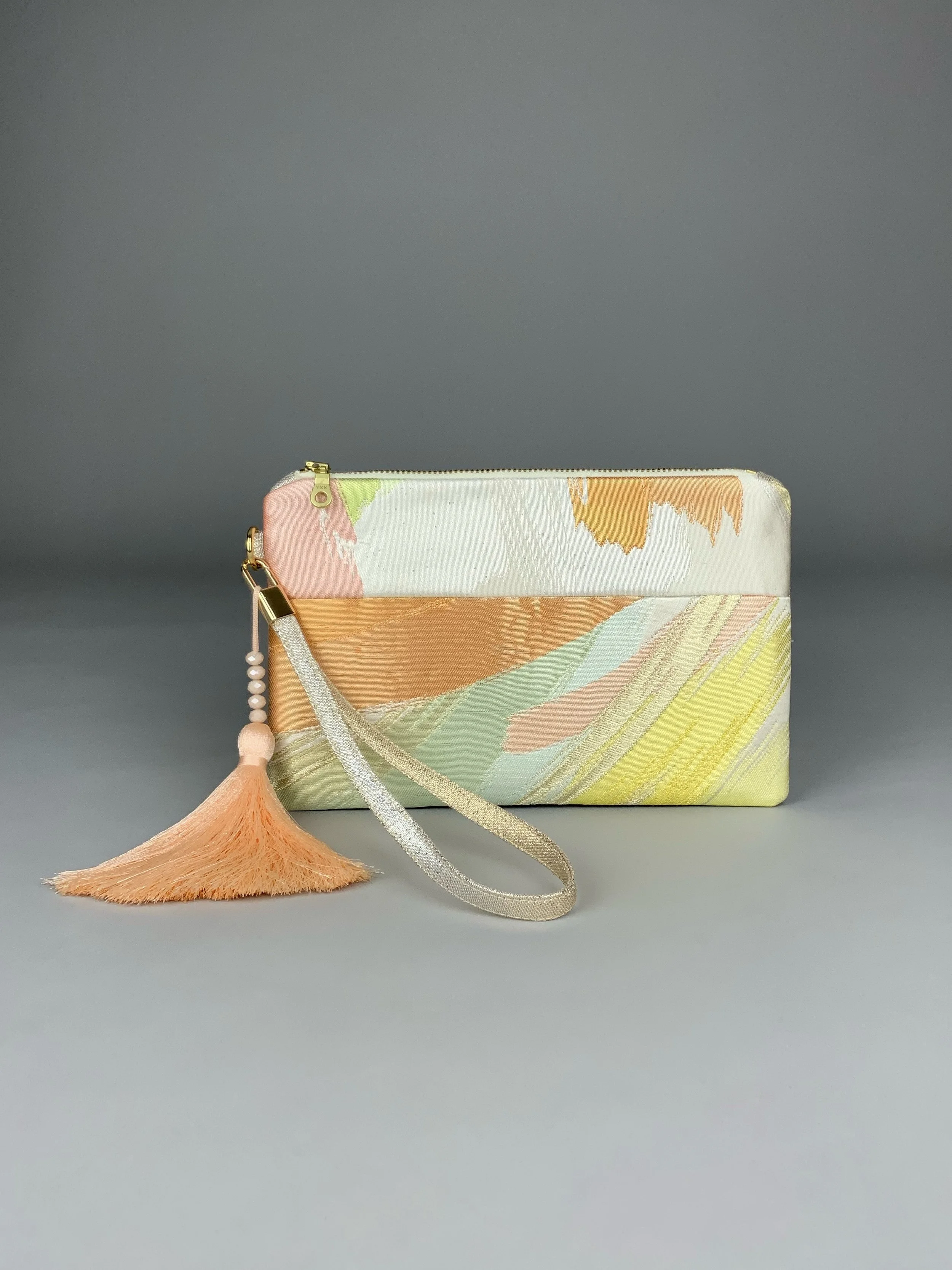Wristlet purse made from repurposed vintage obi fabric with brushstroke pastel design and gold-silver threads