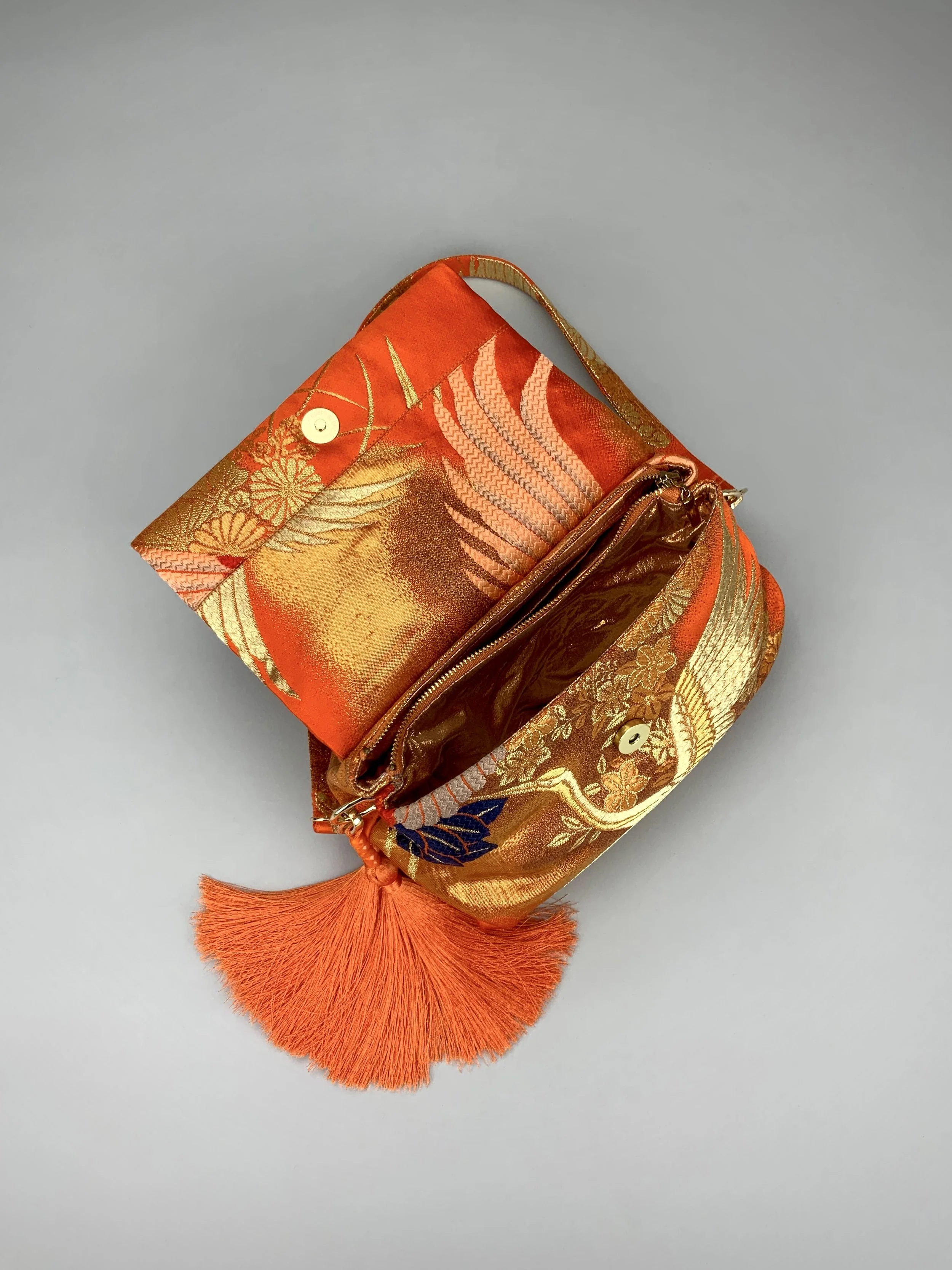 Vibrant orange evening bag with gold copper crane and blossom design, handmade from vintage obi silk by Kirsty Chivers