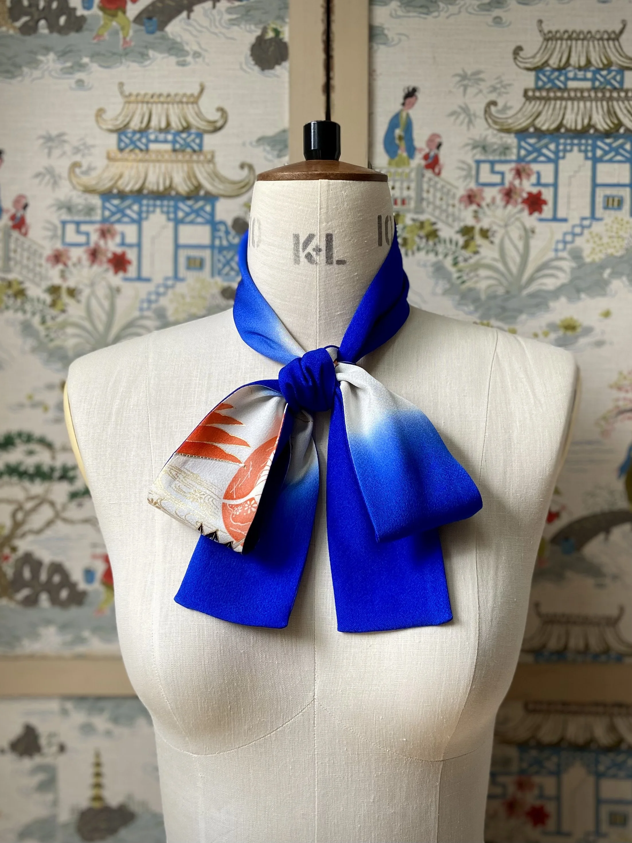 Blue silk scarf, presented on a dress stand, with printed Flying Crane design handmade by Kirsty Chivers