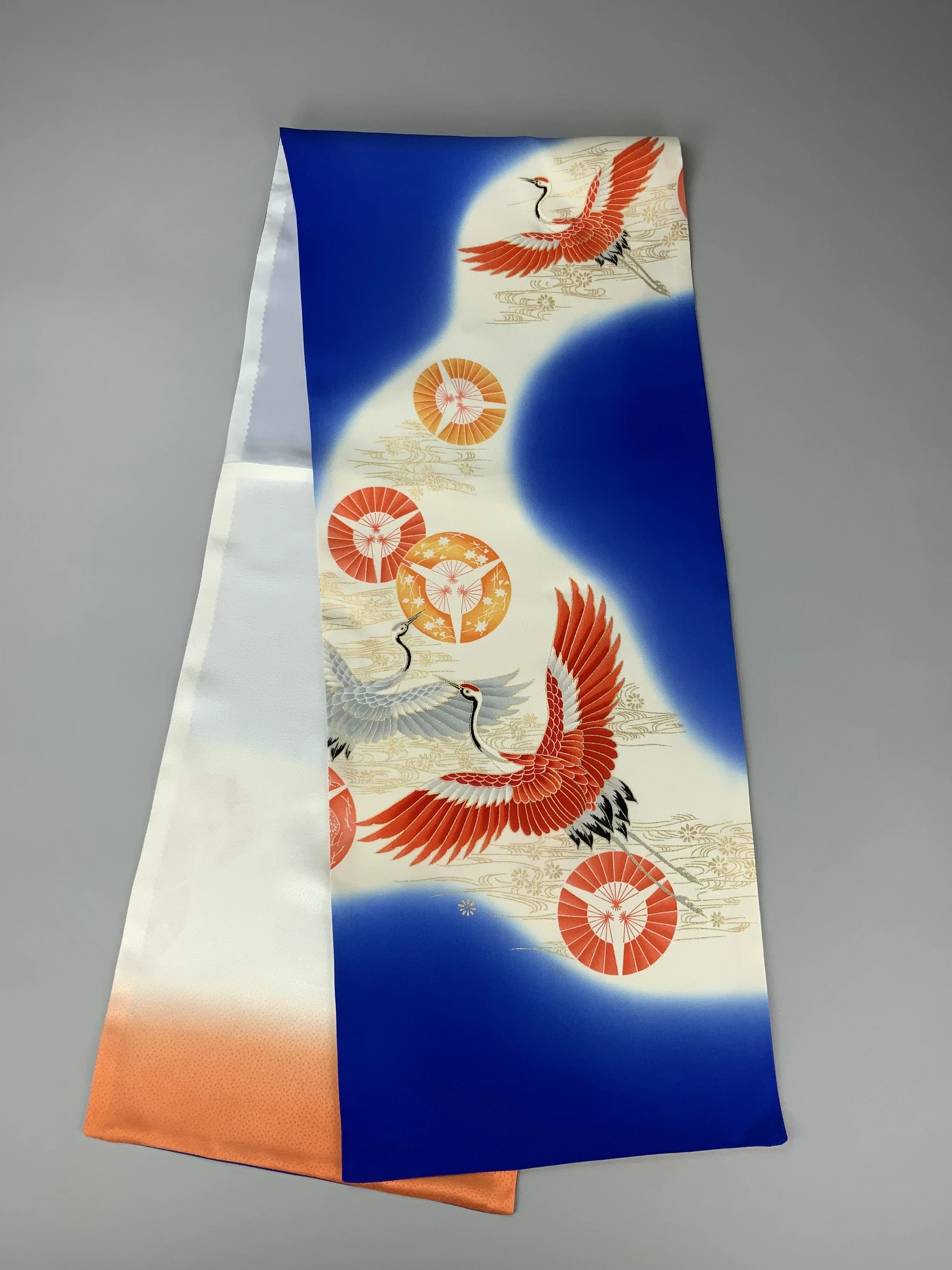 Flatlay of electric blue silk scarf with Flying Crane print handmade by Kirsty Chivers