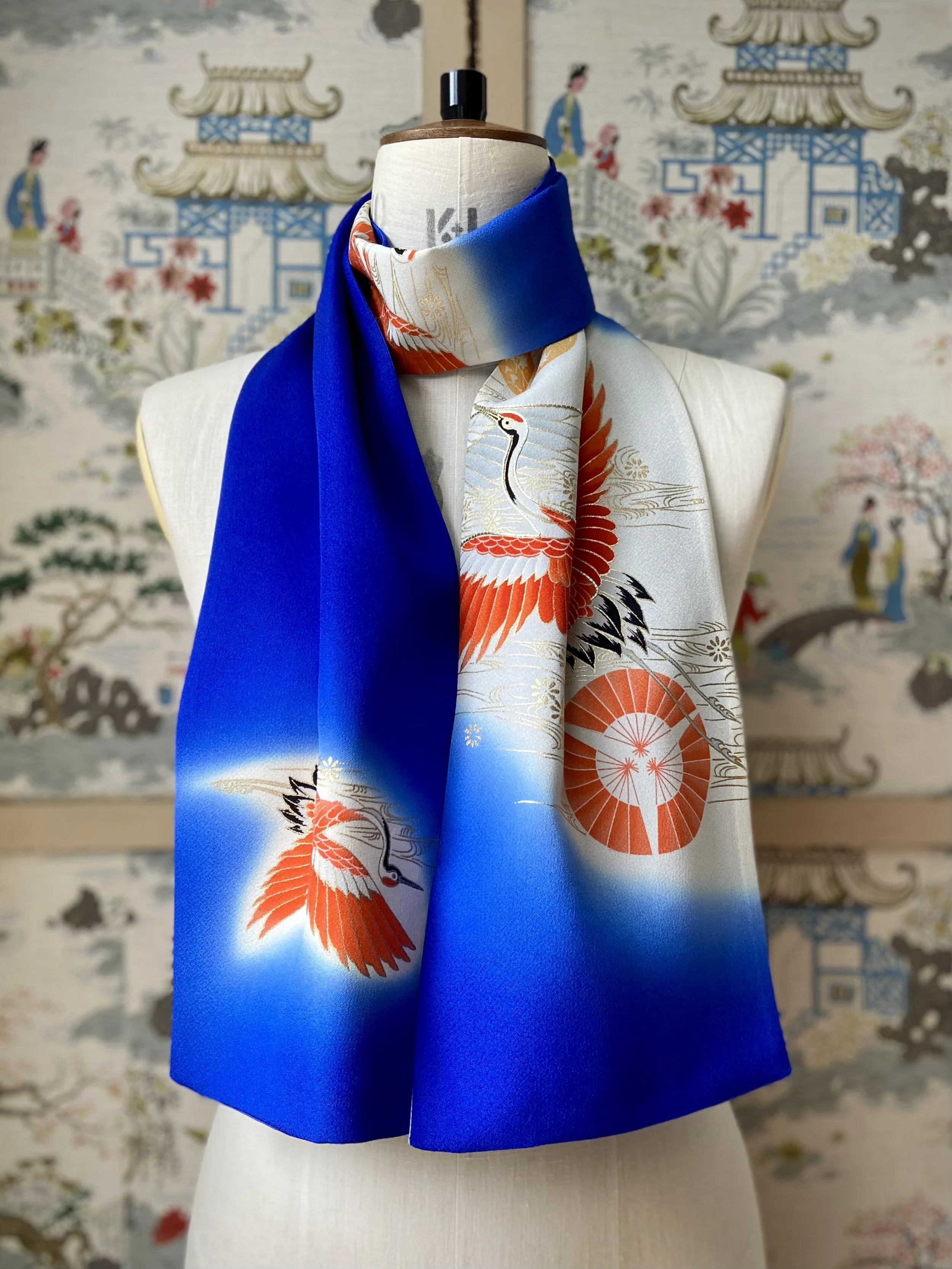 Blue silk scarf, presented on a dress stand, with printed Flying Crane design handmade by Kirsty Chivers
