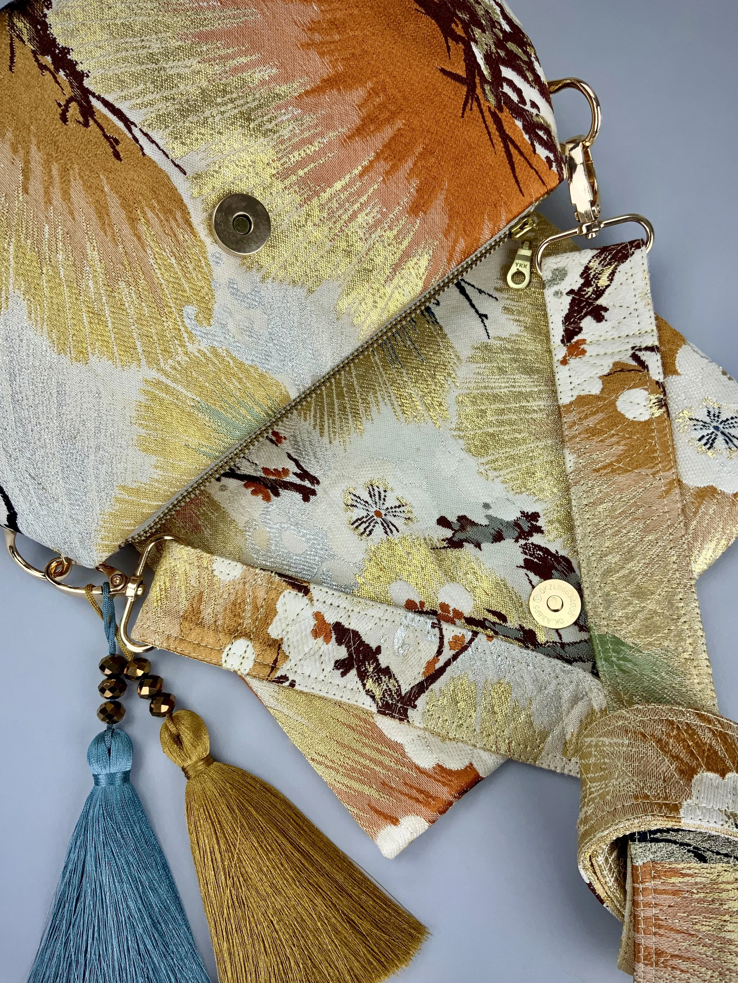 Closeup of metallic gold evening bag with Matsu pine and blossom design, made from vintage obi silk by Kirsty Chivers