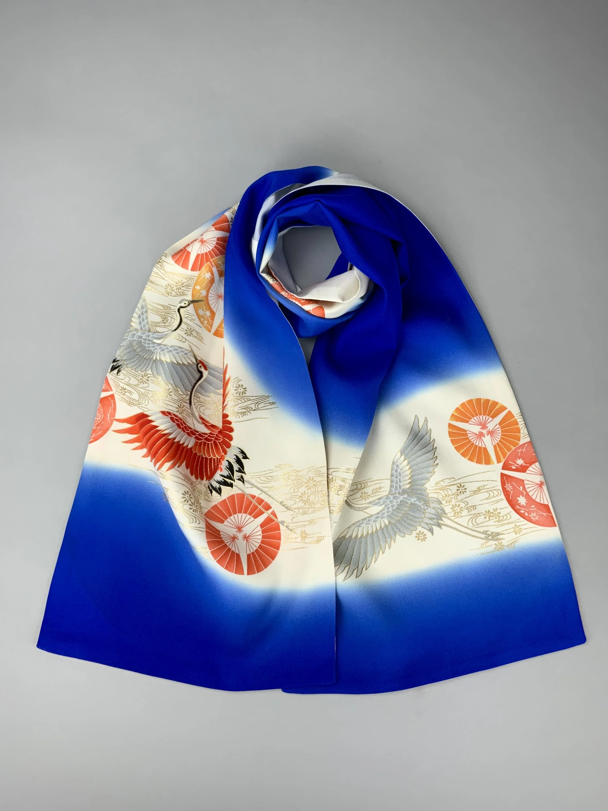 Flatlay of electric blue silk scarf with Flying Crane print handmade by Kirsty Chivers