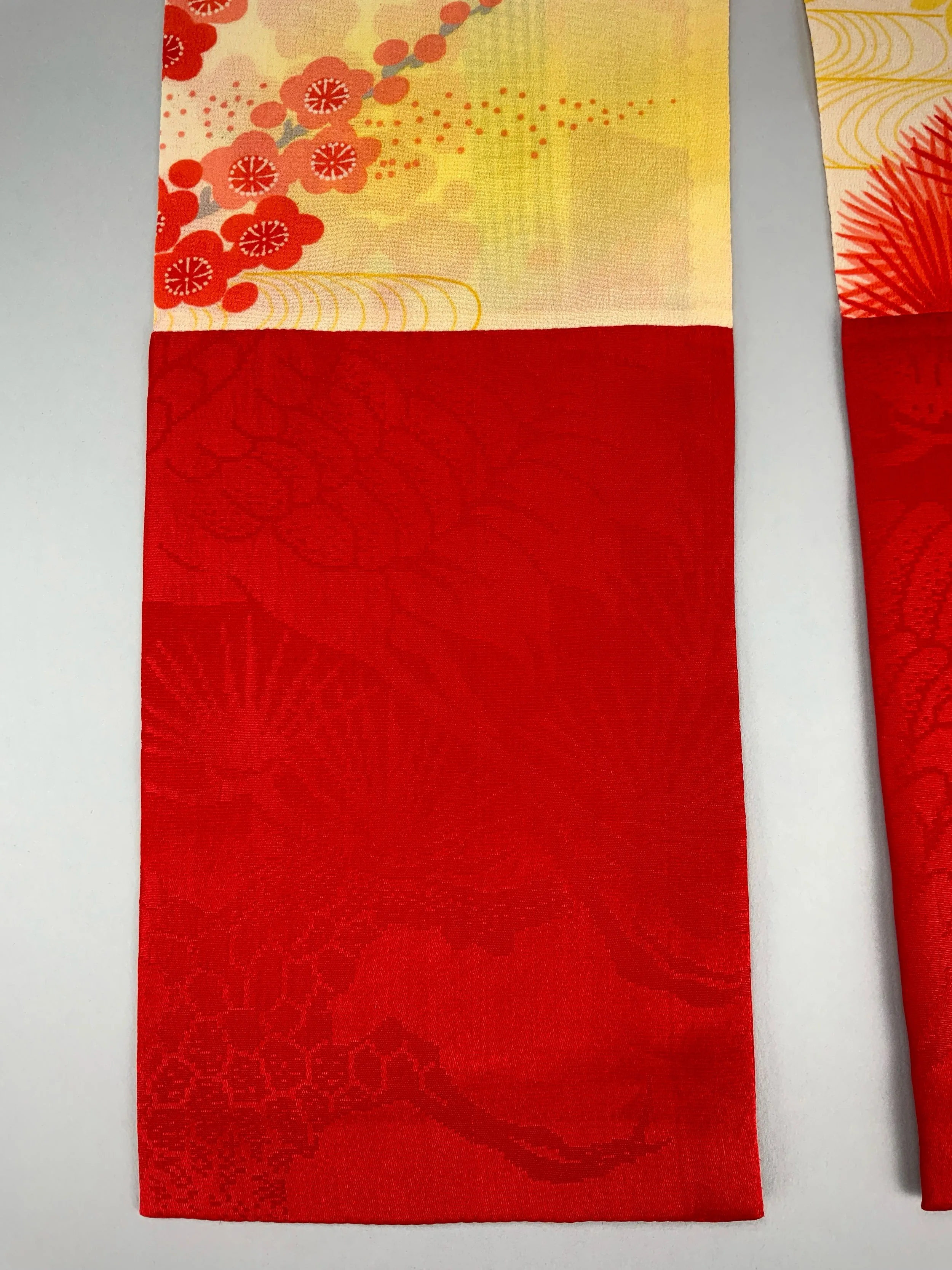 Closeup of vibrant red and yellow scarf with printed blossom design, handmade from repurposed Japanese kimono crepe silk by Kirsty Chivers