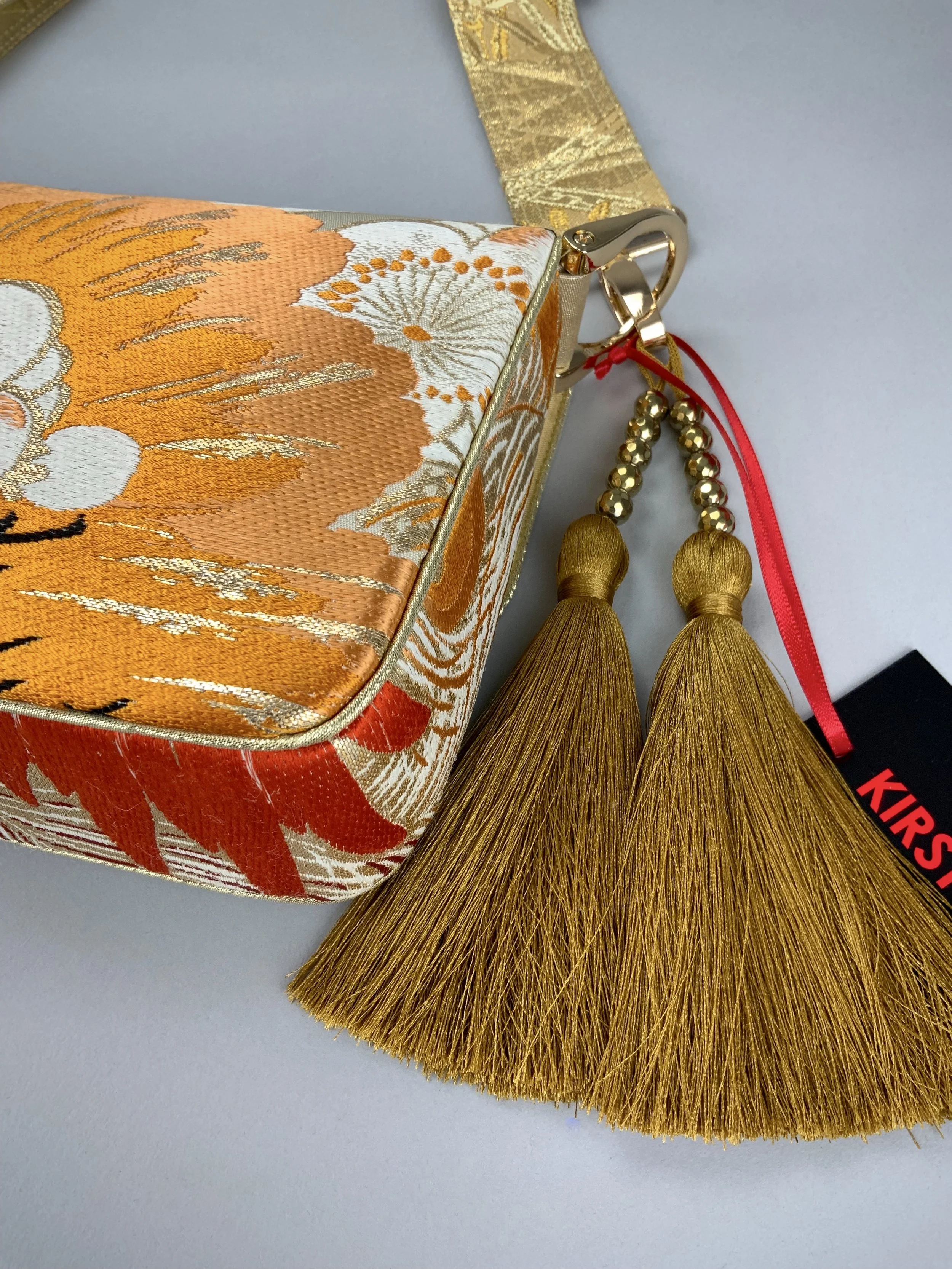 Closeup of unique evening bag in vintage obi silk with peacock, pine motifs & gold accents by Kirsty Chivers