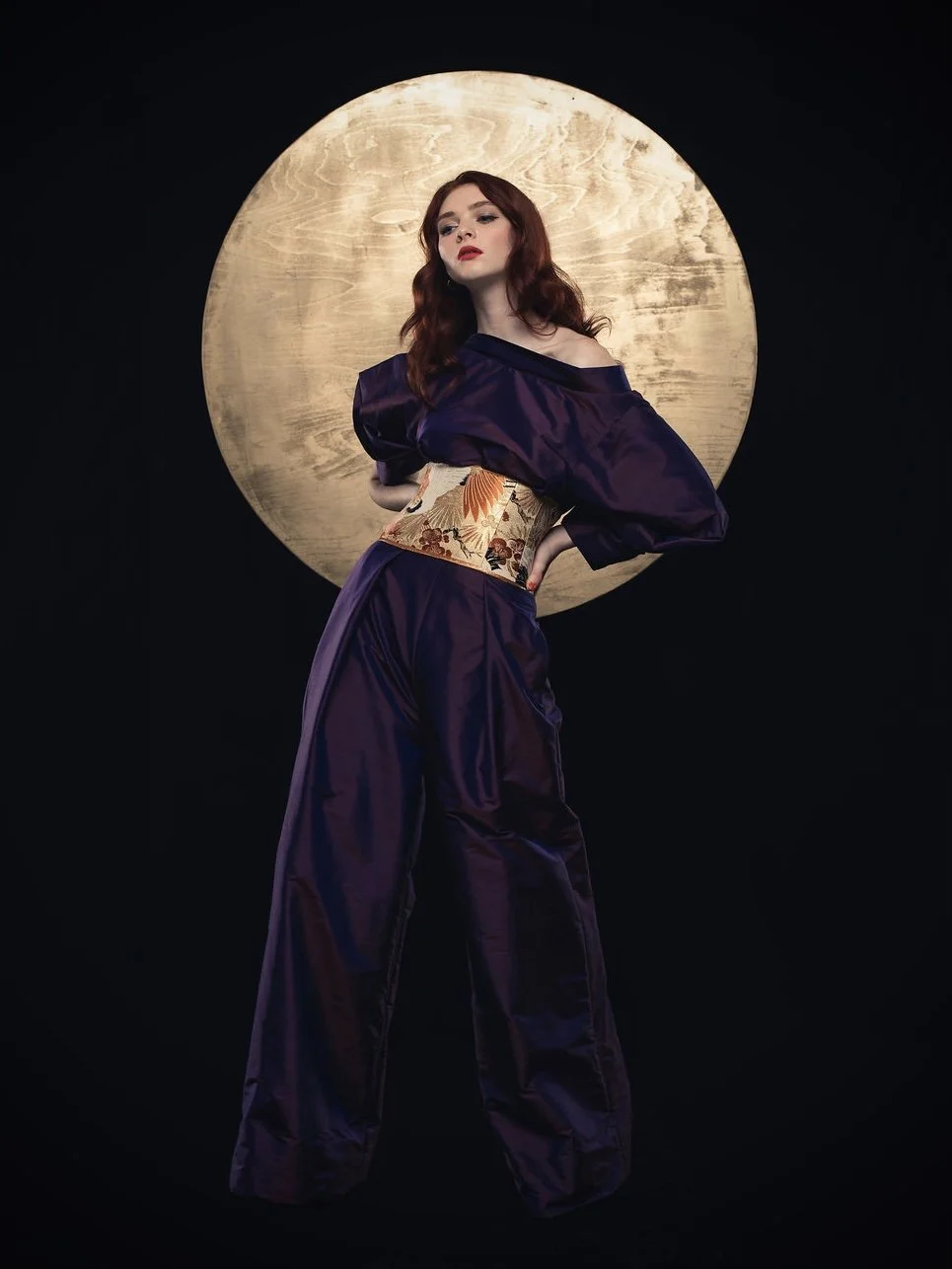 Model in front of full moon wearing handmade obi belt and jumpsuit by Kirsty Chivers